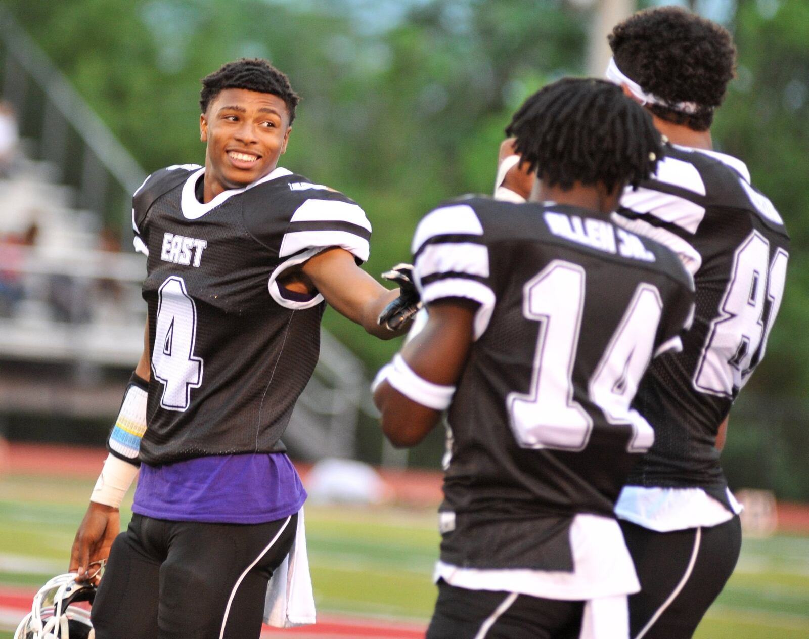 Middletown’s Shandon Morris (4) shares a laugh with East teammates Andre Allen Jr. (14) and Caleb Diersing (81) of Walnut Hills on Thursday night during the 44th Southwestern Ohio Football Coaches Association Ron Woyan East-West All-Star Game at Kings Stadium. The East won 39-7. RICK CASSANO/STAFF