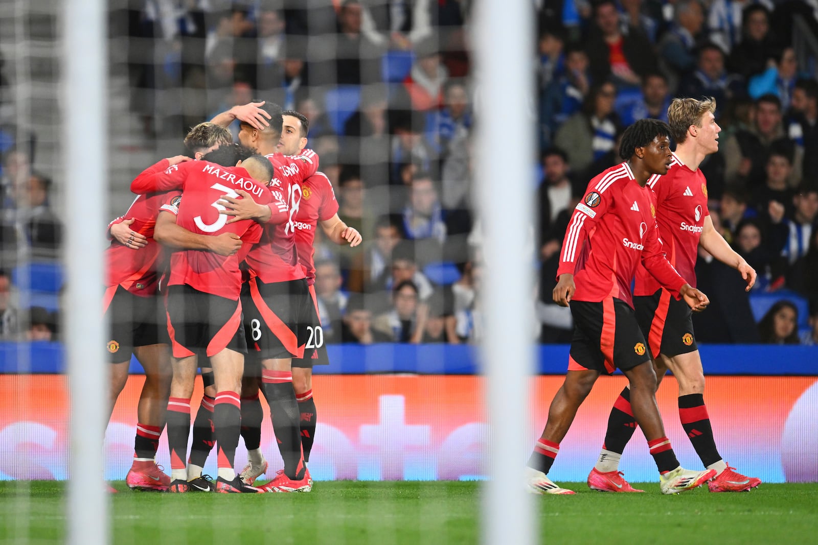 Manchester United players celebrate after Manchester United's Joshua Zirkzee scored his side's opening goal during the Europa League round of 16 first leg soccer match between Real Sociedad and Manchester United at the Reale Arena in San Sebastian, Spain, Thursday, March 6, 2025. (AP Photo/Miguel Oses)