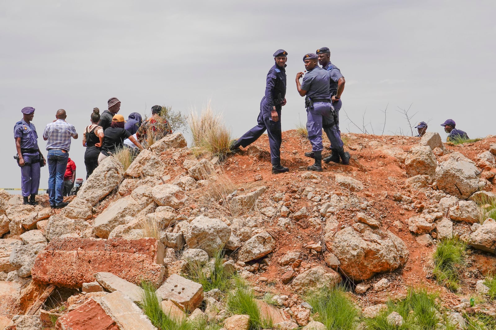 Police officers and volunteer rescuers stand by the opening of a reformed gold mineshaft where illegal miners are trapped in Stilfontein, South Africa, Friday, Nov. 15, 2024. (AP Photo/Denis Farrell)