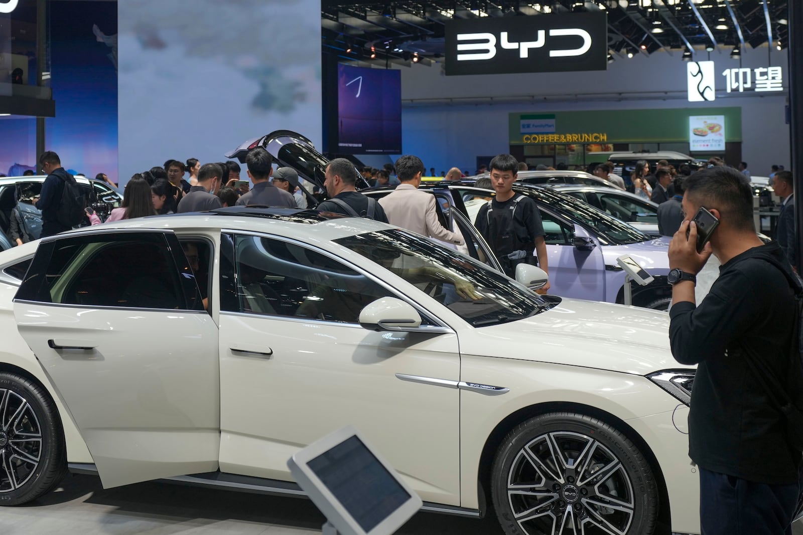 FILE - Visitors look at cars at the BYD booth during the China Auto Show in Beijing, China, April 26, 2024. (AP Photo/Tatan Syuflana, File)