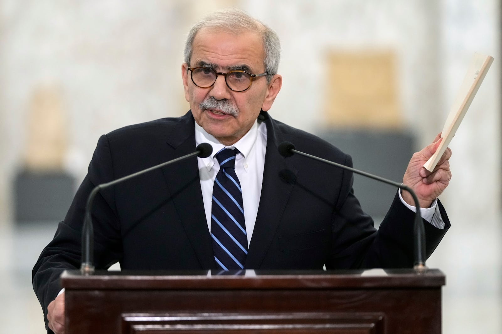 Lebanese Prime Minister-designate Nawaf Salam holds up a copy of the Lebanese Constitution as he speaks to journalists after his meeting with Lebanese President Joseph Aoun at the presidential palace in Baabda, east of Beirut, Lebanon, Tuesday, Jan. 14, 2025. (AP Photo/Hassan Ammar)