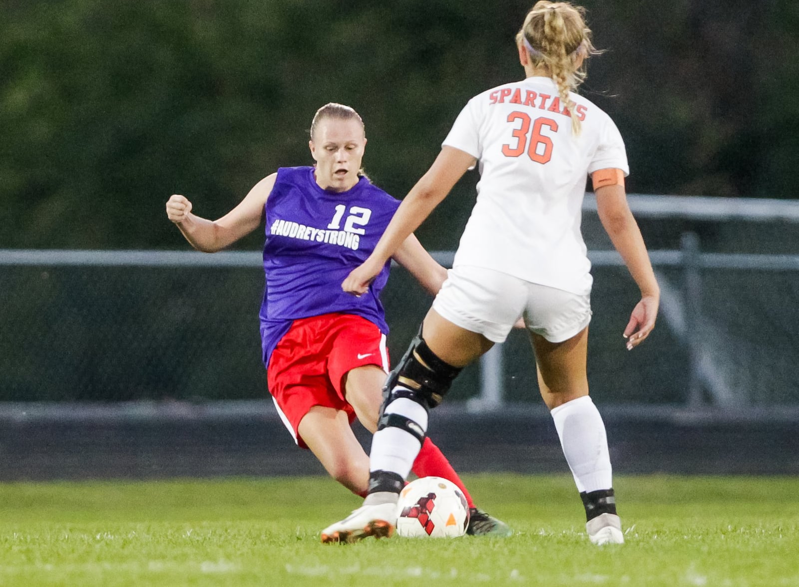 Fenwick’s Audrey Swisher (12) kicks the ball while being defended by Waynesville’s Anna Miller (36) on Monday night at Fenwick. Swisher, a senior who’s been fighting cystic fibrosis since she was born, was playing in her first game in about a month. NICK GRAHAM/STAFF