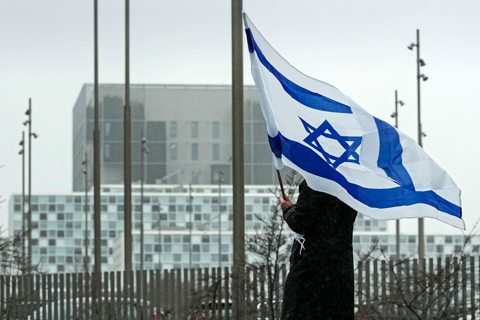 FILE - A woman holds an Israeli flag in front of International Criminal Court at The Hague, Netherlands, Feb. 14, 2024. (AP Photo/Martin Meissner, File)