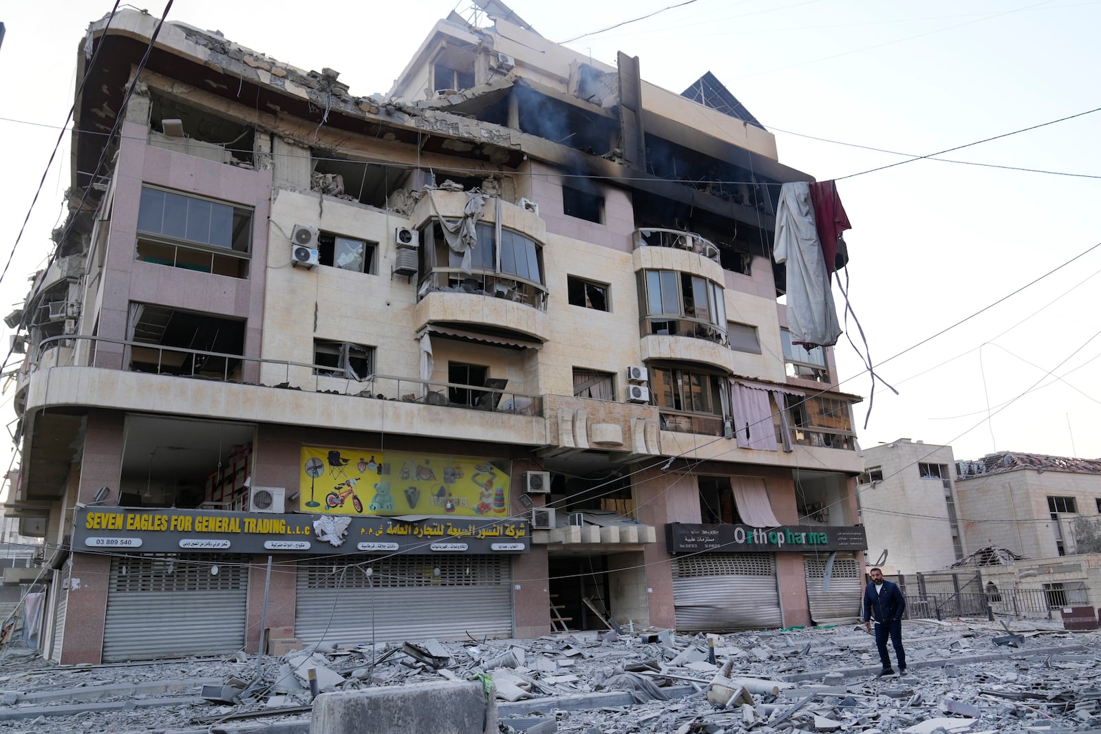 A man passes a destroyed building hit by an Israeli airstrike on Dahiyeh, in the southern suburb of Beirut, Lebanon, Friday, Nov. 1, 2024. (AP Photo/Hussein Malla)