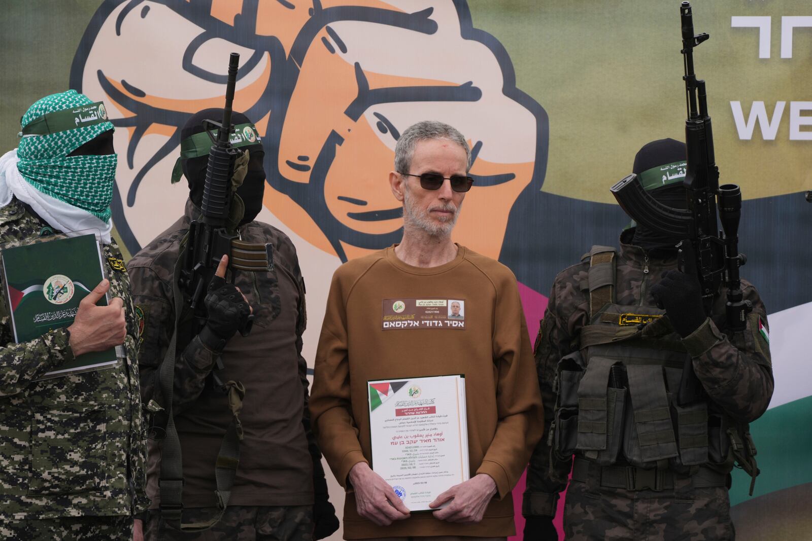 Israeli captive Ohad Ben Ami, who has been held hostage by Hamas in Gaza since October 7, 2023, is escorted by Hamas fighters before being handed over to the Red Cross in Deir al-Balah, central Gaza Strip, Saturday Feb. 8, 2025. (AP Photo/Abdel Kareem Hana)