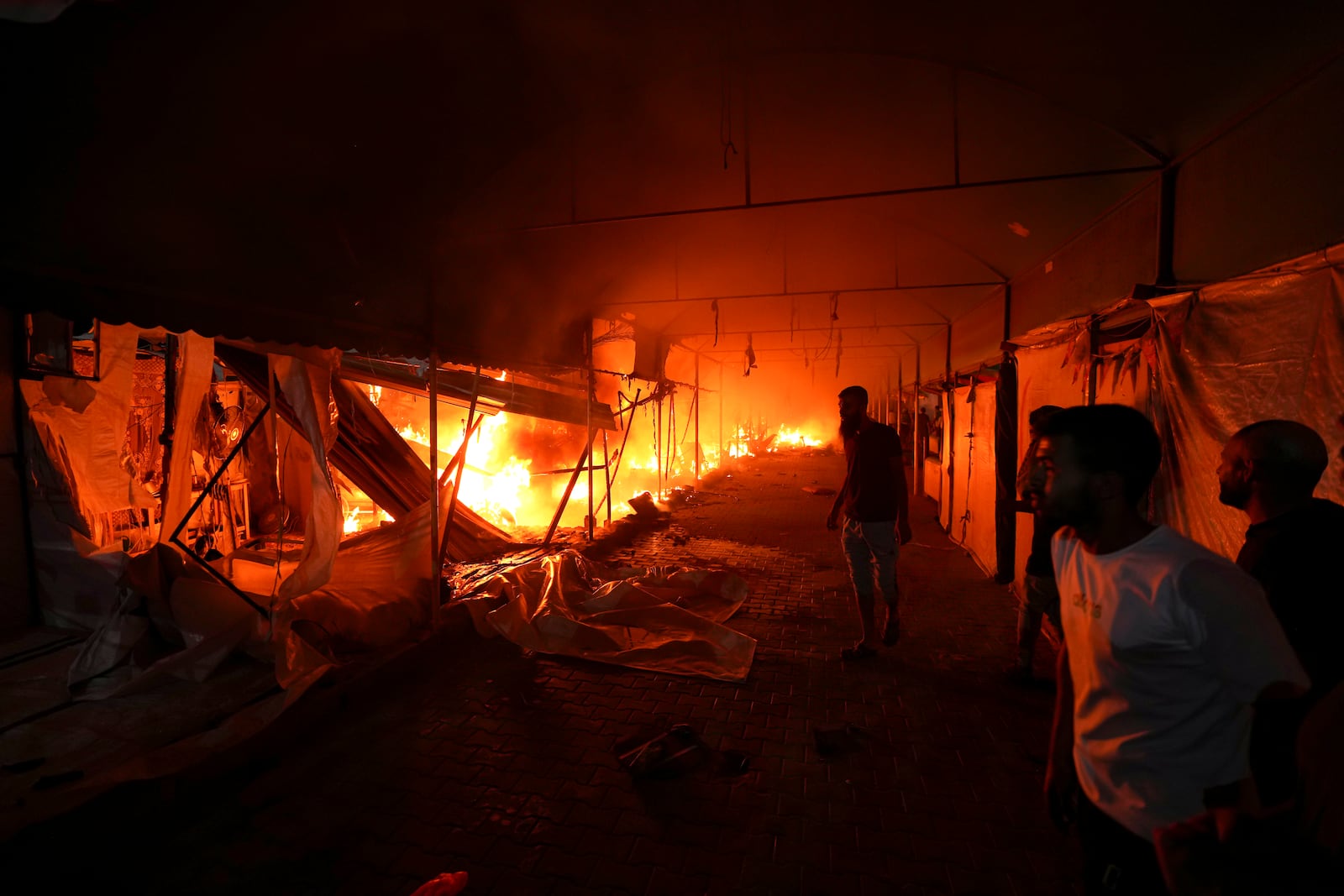 FILE - Palestinians react to a fire after an Israeli strike hit a tent area in the courtyard of Al Aqsa Martyrs hospital in Deir al-Balah, Gaza Strip, Monday, Oct. 14, 2024. (AP Photo/Abdel Kareem Hana, File)