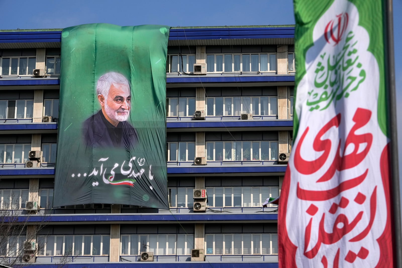 A portrait of the late Iranian Revolutionary Guard Gen. Qassem Soleimani, who was killed in a U.S. drone attack in 2020, hangs on a government building during a rally commemorating anniversary of 1979 Islamic Revolution that toppled the late pro-U.S. Shah Mohammad Reza Pahlavi and brought Islamic clerics to power, in Tehran, Iran, Monday, Feb. 10, 2025. (AP Photo/Vahid Salemi)