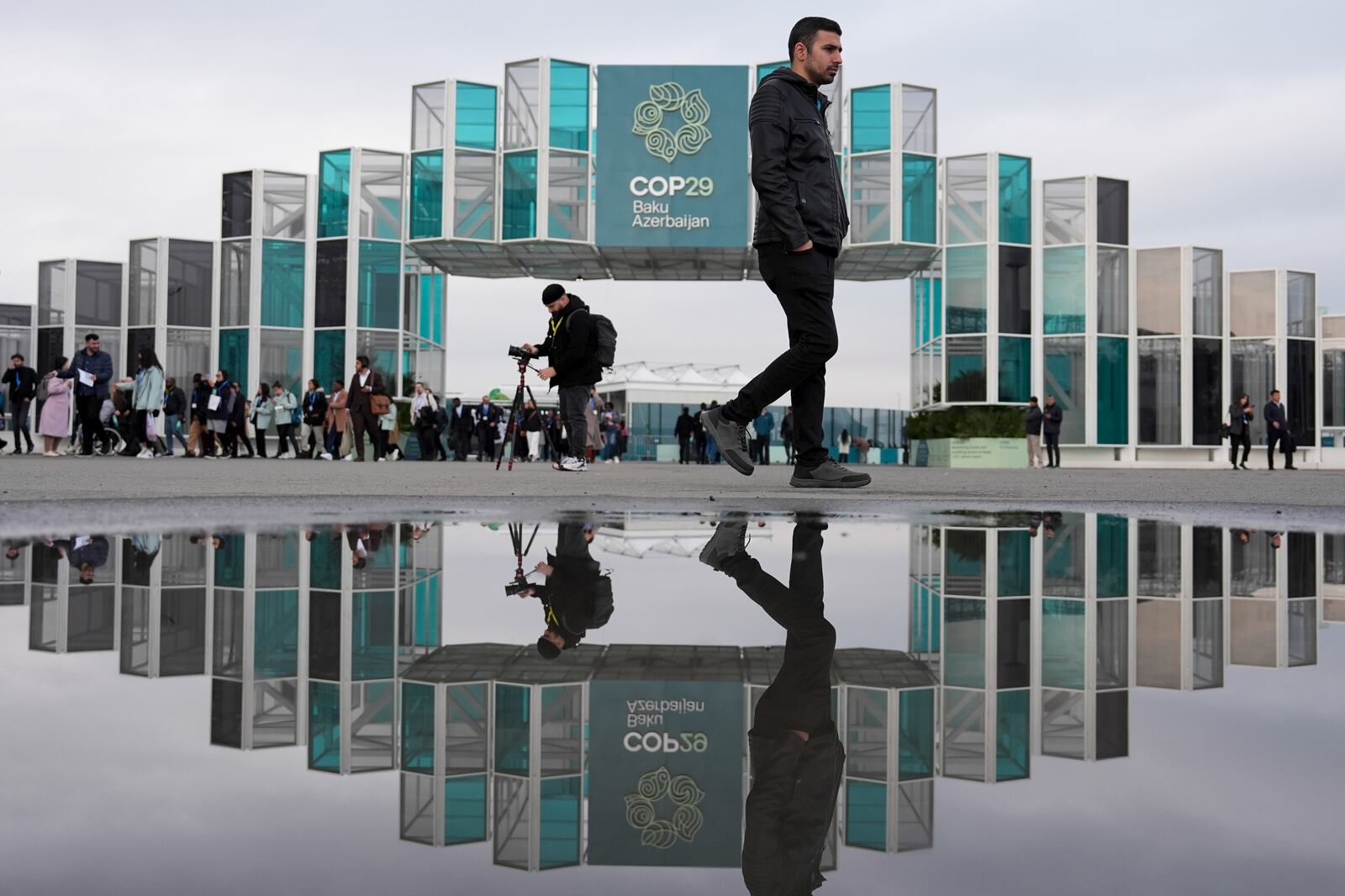 FILE - People arrive for the day at the COP29 U.N. Climate Summit, Nov. 19, 2024, in Baku, Azerbaijan. (AP Photo/Joshua A. Bickel, File)