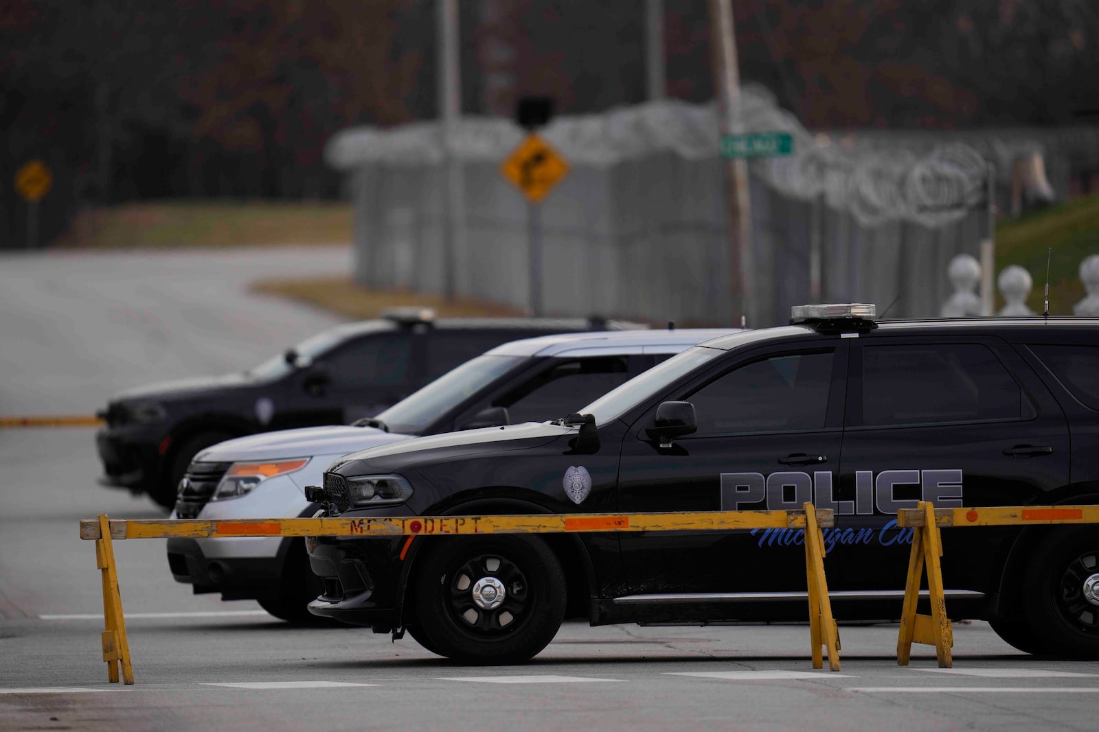 Police cars are parked outside of Indiana State Prison where, barring last-minute court action or intervention by Gov. Eric Holcomb, Joseph Corcoran, 49, convicted in the 1997 killings of his brother and three other people, is scheduled to be put to death by lethal injection before sunrise Tuesday, Dec. 17, 2024, in Michigan City, Ind. (AP Photo/Erin Hooley)