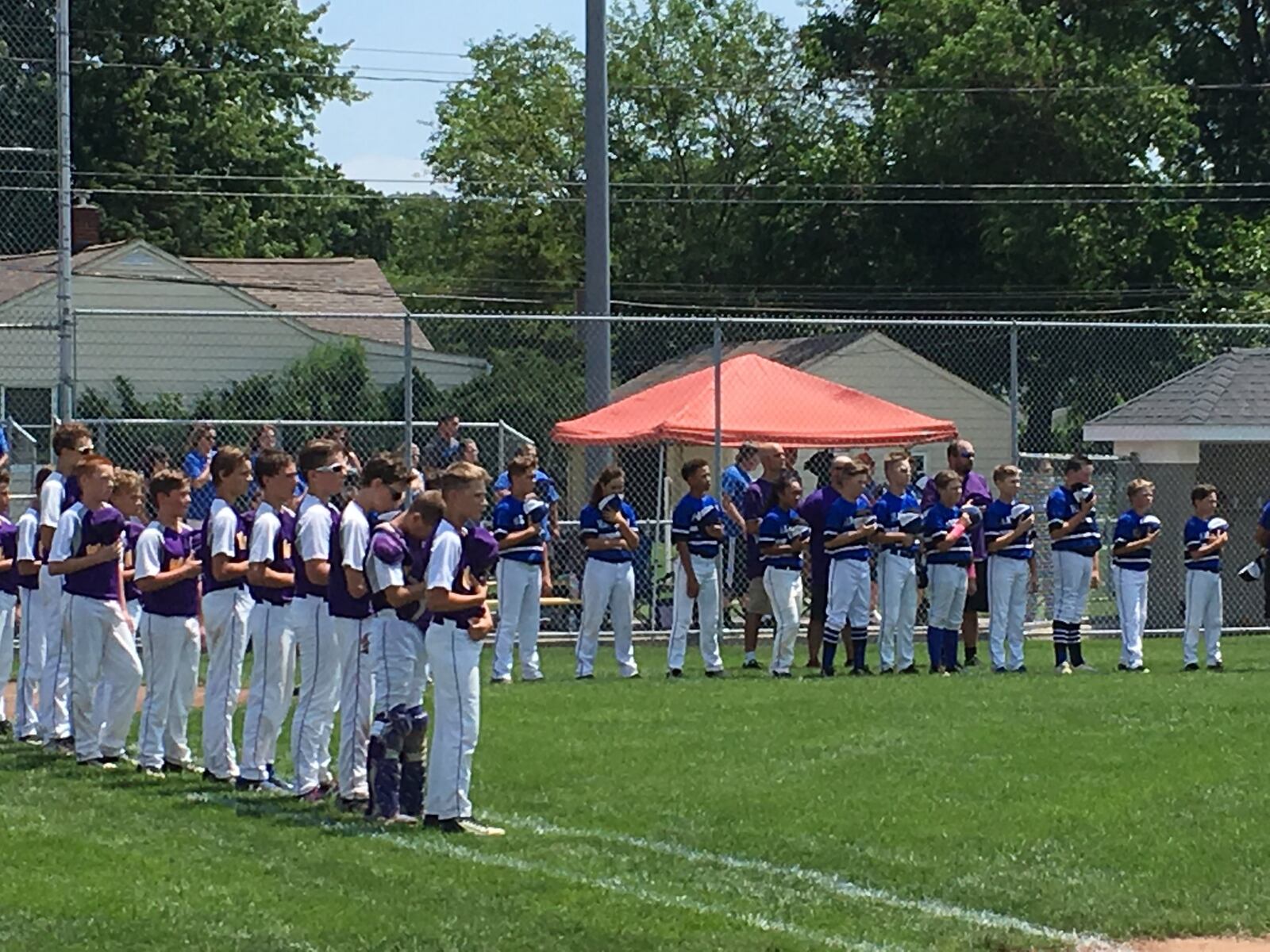 Hamilton West Side is on the third-base line and Maumee is on the first-base line Sunday during the National Anthem at Ford Park. West Side recorded a 13-4 win in the Ohio Little League 12-year-old tournament in Maumee. RICK CASSANO/STAFF