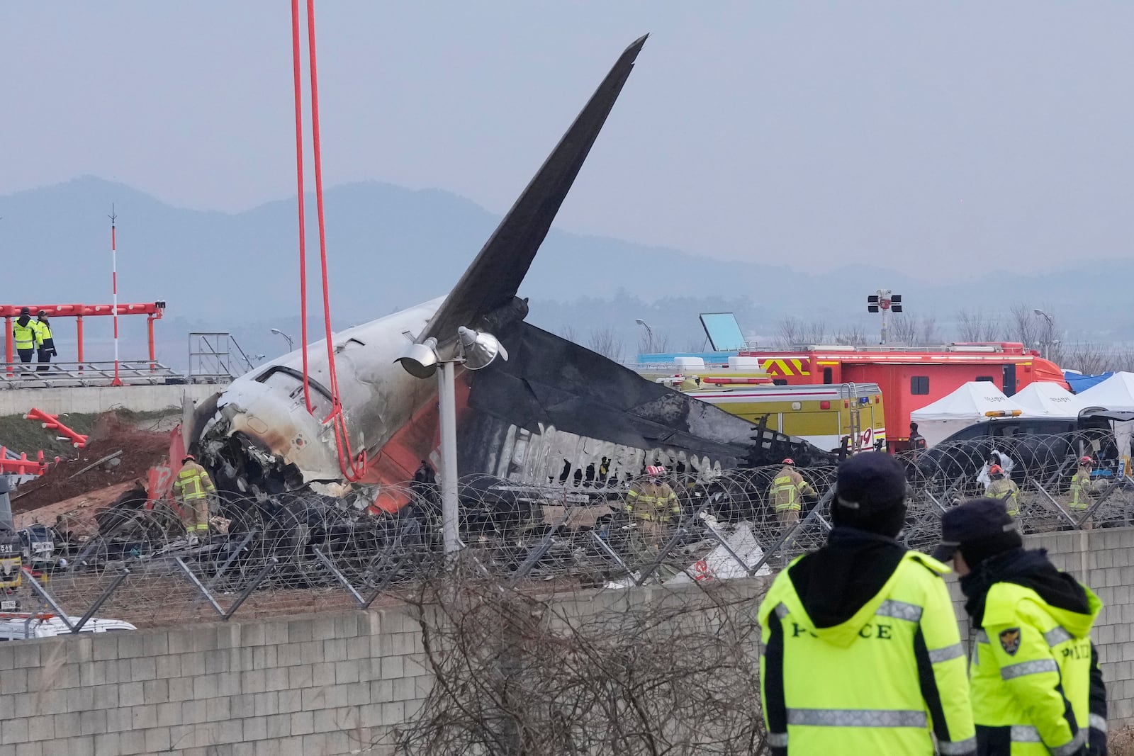 Rescue team members work at the site of a plane fire at Muan International Airport in Muan, South Korea, Monday, Dec. 30, 2024. (AP Photo/Ahn Young-joon)