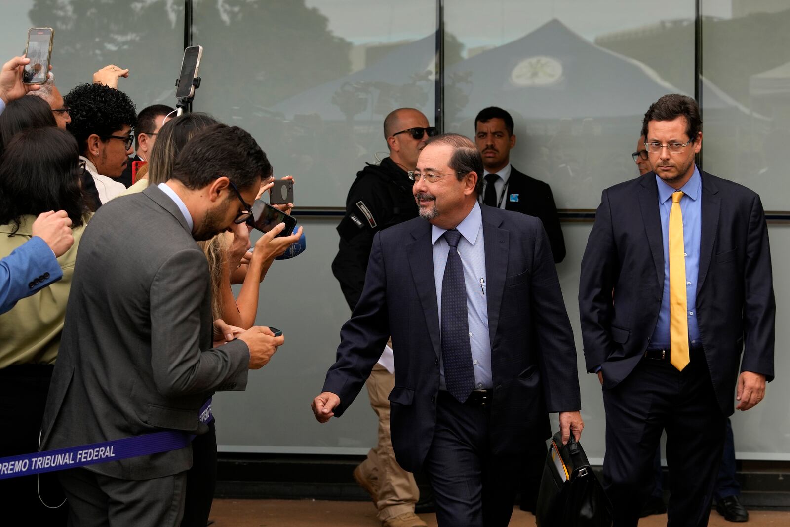 Celso Villares, center, and Fabio Wajngarten, right, lawyers for Brazil's former President Jair Bolsonaro, arrive at the Supreme Court for his trial in Brasilia, Brazil, Tuesday, March 25, 2025. (AP Photo/Eraldo Peres)