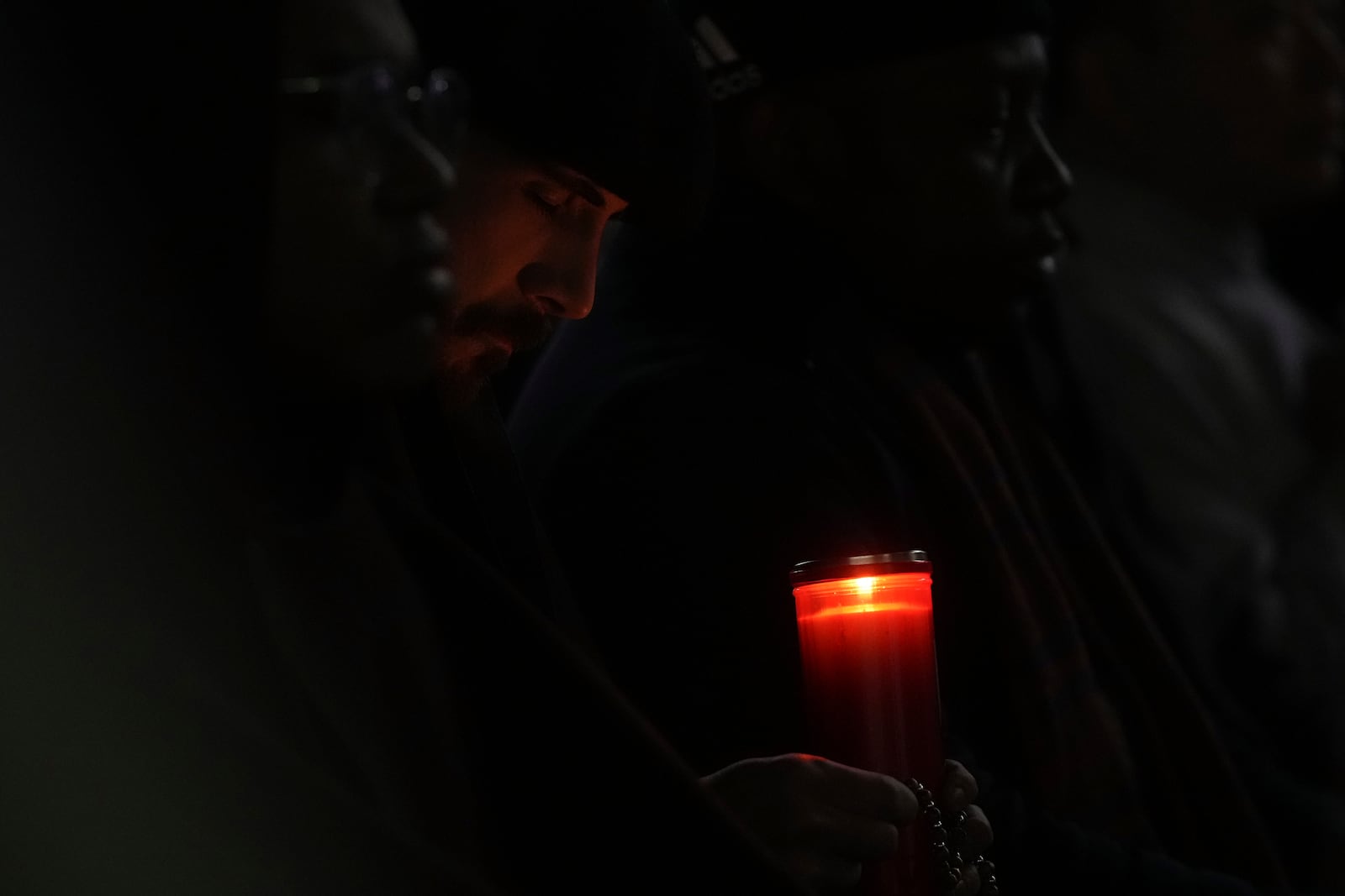 A man holds a candle during a rosary prayer for Pope Francis' health in St. Peter's Square at the Vatican, Tuesday, March 4, 2025. (AP Photo/Alessandra Tarantino)