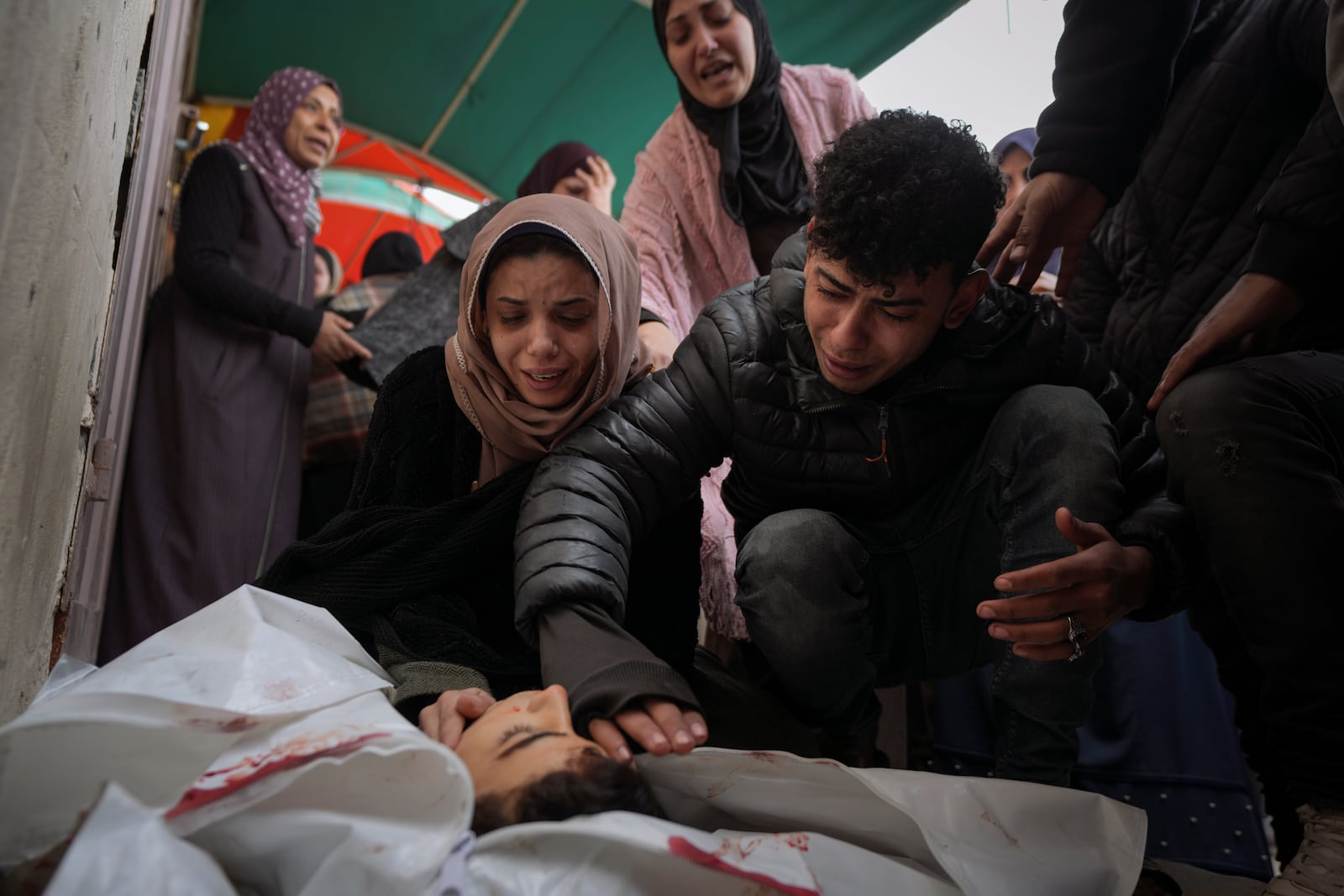 Relatives of Mohammed Al Mabhouh,15, who was killed by the Israeli bombardment of the Gaza Strip, mourn over his body at Al-Aqsa Martyrs Hospital in Deir al-Balah, Sunday, Jan. 5, 2025. (AP Photo/Abdel Kareem Hana)