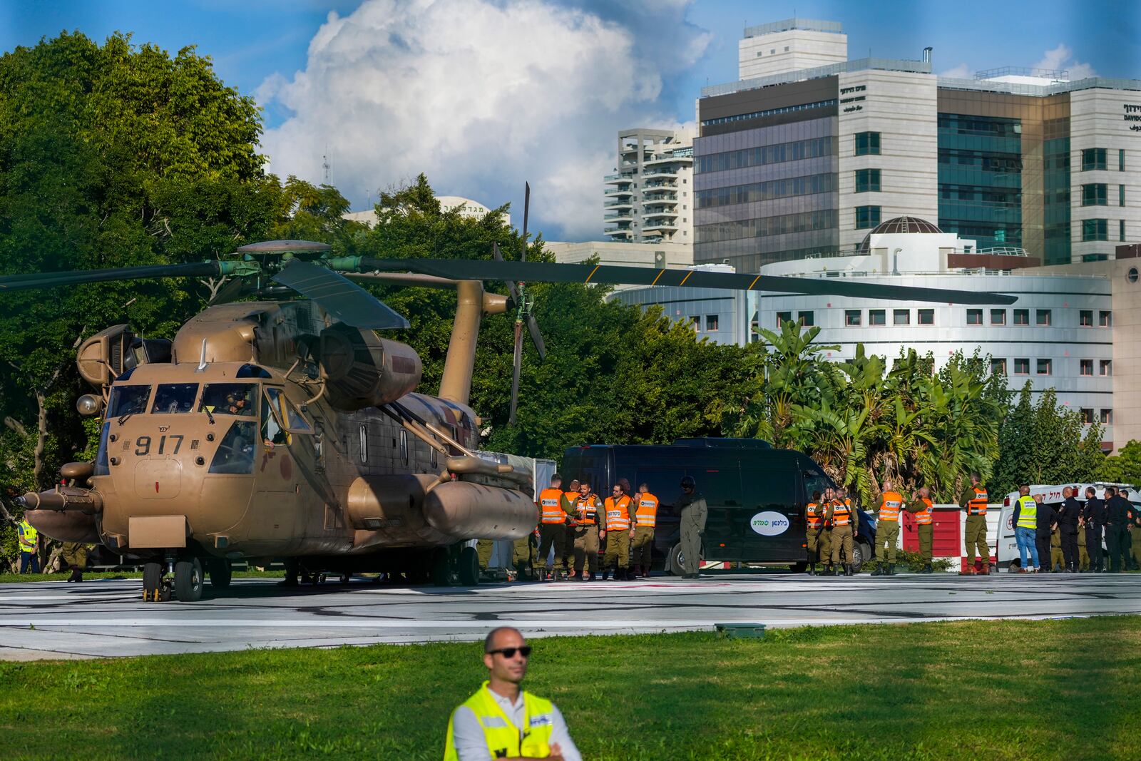 Israeli staff and military stand next to the military helicopter, carrying the four Israeli female soldier released from Gaza, after landing at the Beilinson hospital in Petah Tikva, near Tel Aviv, Israel, Saturday, Jan. 25, 2025. (AP Photo/Maya Alleruzzo)