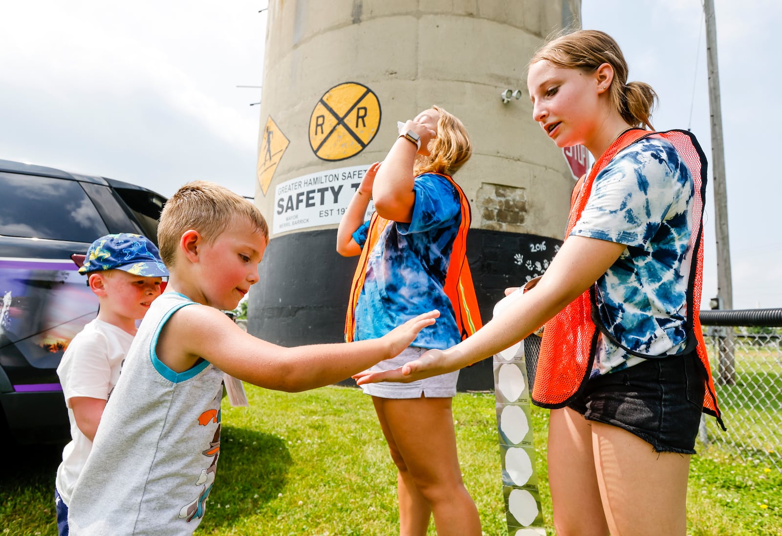 Eli Price gives five to volunteer Paige Goldman, 13, right, at Safety Town Monday, June 13, 2022 at Office Bob Gentry Park in Hamilton. This is the 50th year of Safety Town in Hamilton. Four and five year old children are instructed in pedestrian, vehicle, bus, gun and fire safety. NICK GRAHAM/STAFF