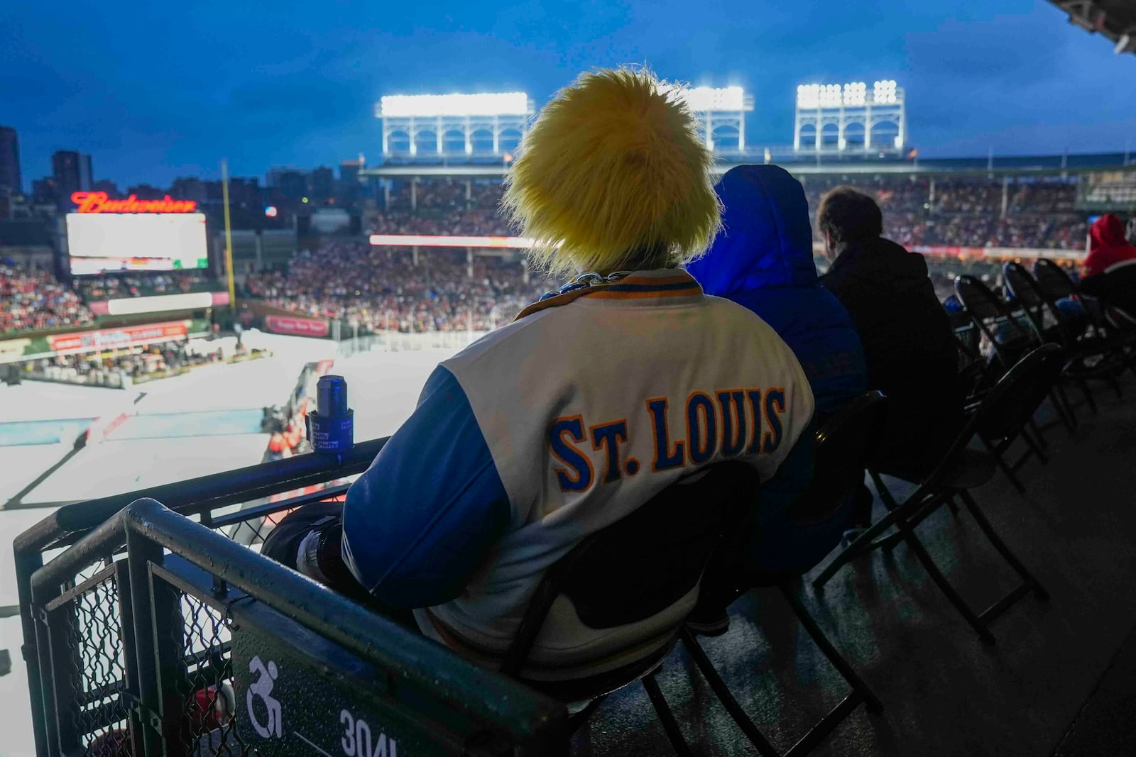 A St. Louis Blues fan watches the NHL Winter Classic outdoor hockey game between the Chicago Blackhawks and the Blues at Wrigley Field, Tuesday, Dec. 31, 2024, in Chicago. (AP Photo/Erin Hooley)