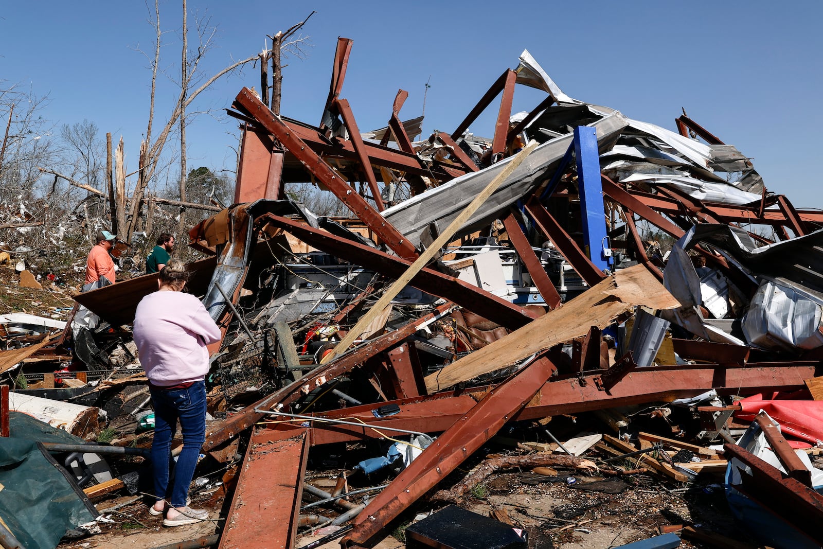 Friends and family members search for belongings in the damage after a tornado passed through the area, Sunday, March 16, 2025, in Plantersville, Ala. (AP Photo/Butch Dill)