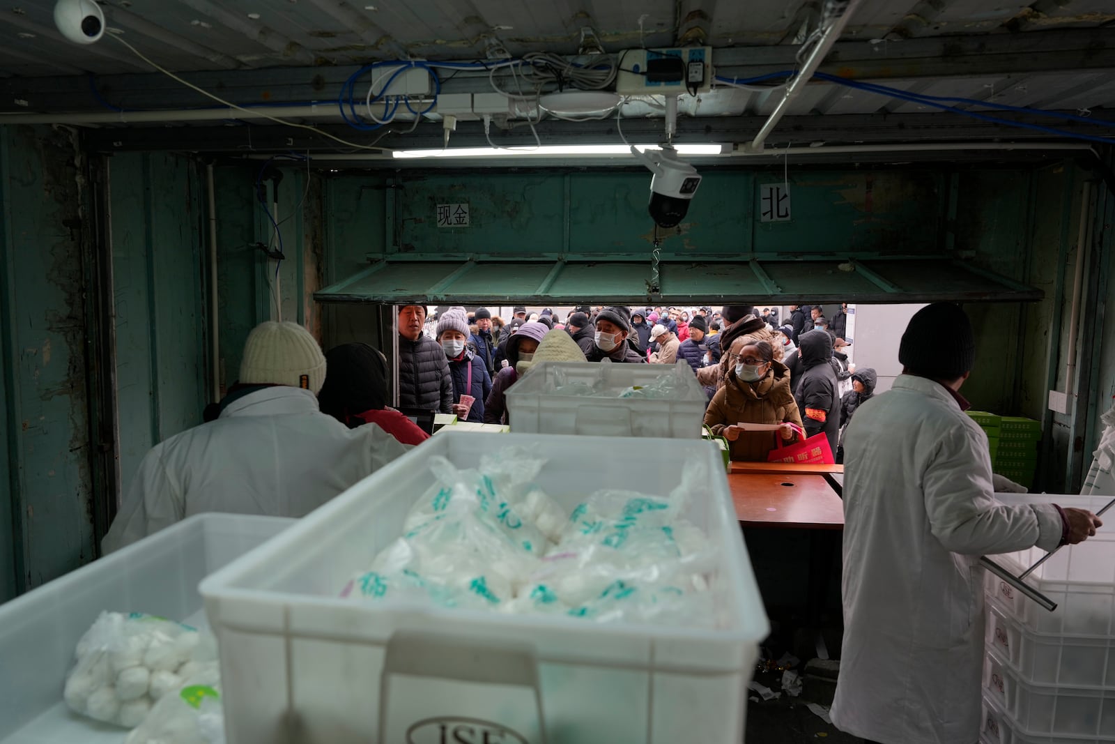 Residents line up to buy yuanxiao, a traditional Chinese food made with glutinous rice flour and sweet fillings consumed as part of the upcoming Lantern Festival celebrations, at the Jinfang Snacks Shop in Beijing, Tuesday, Feb. 11, 2025. (AP Photo/Ng Han Guan)