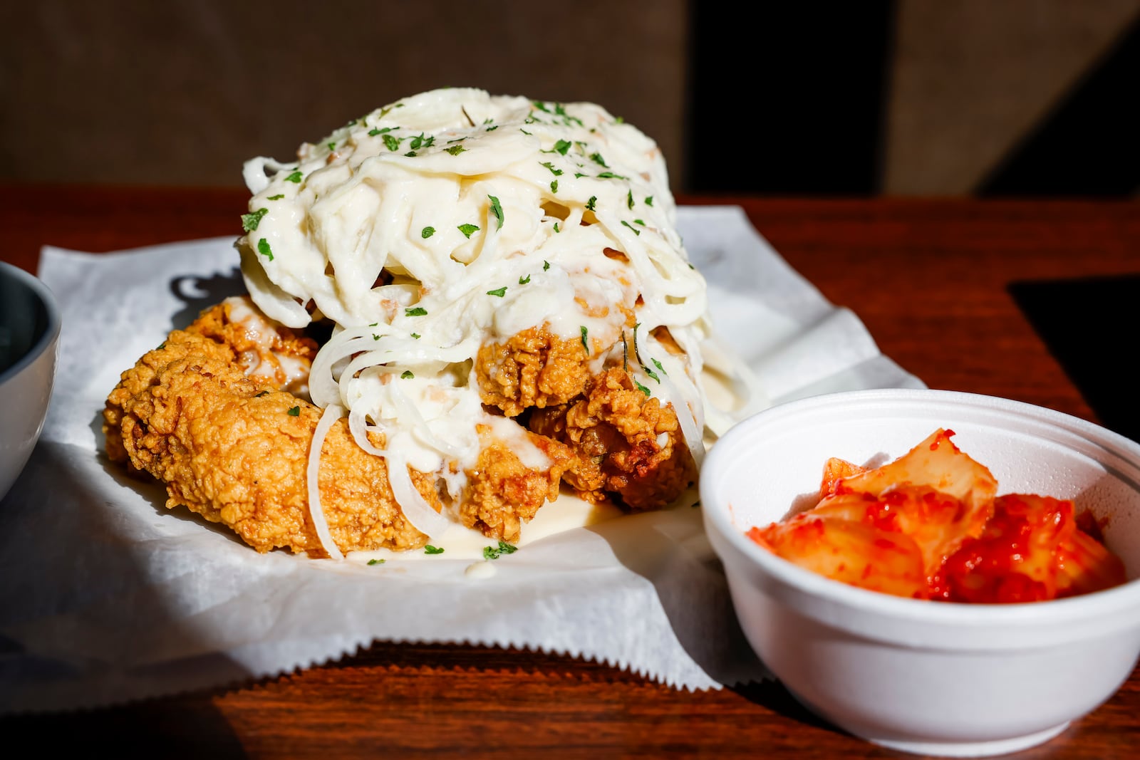 CM Chicken is a Korean fried chicken restaurant and bar located at 7206 Towne Centre Dr. in Liberty Township. This is their snow onion original with wings served with kimchi, white rice and pickled radish. NICK GRAHAM/STAFF