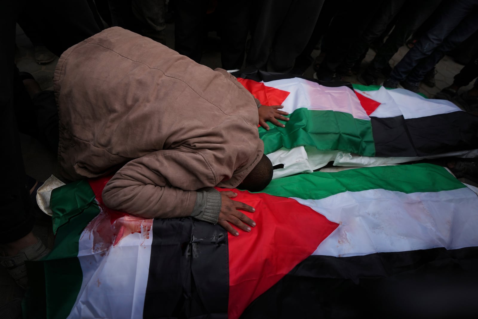 Palestinians mourn their relatives killed in the Israeli bombardment of the Gaza Strip, at Al-Aqsa Martyrs Hospital in Deir al-Balah, Sunday, Jan. 5, 2025. (AP Photo/Abdel Kareem Hana)