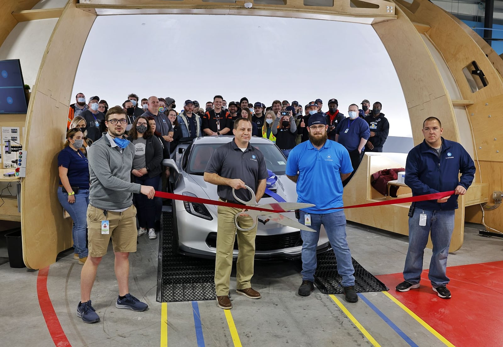 Carvana, a car processing center in Trenton, held its ribbon-cutting Friday afternoon. General manager Justin Nelsen holds the scissors. NICK GRAHAM/STAFF