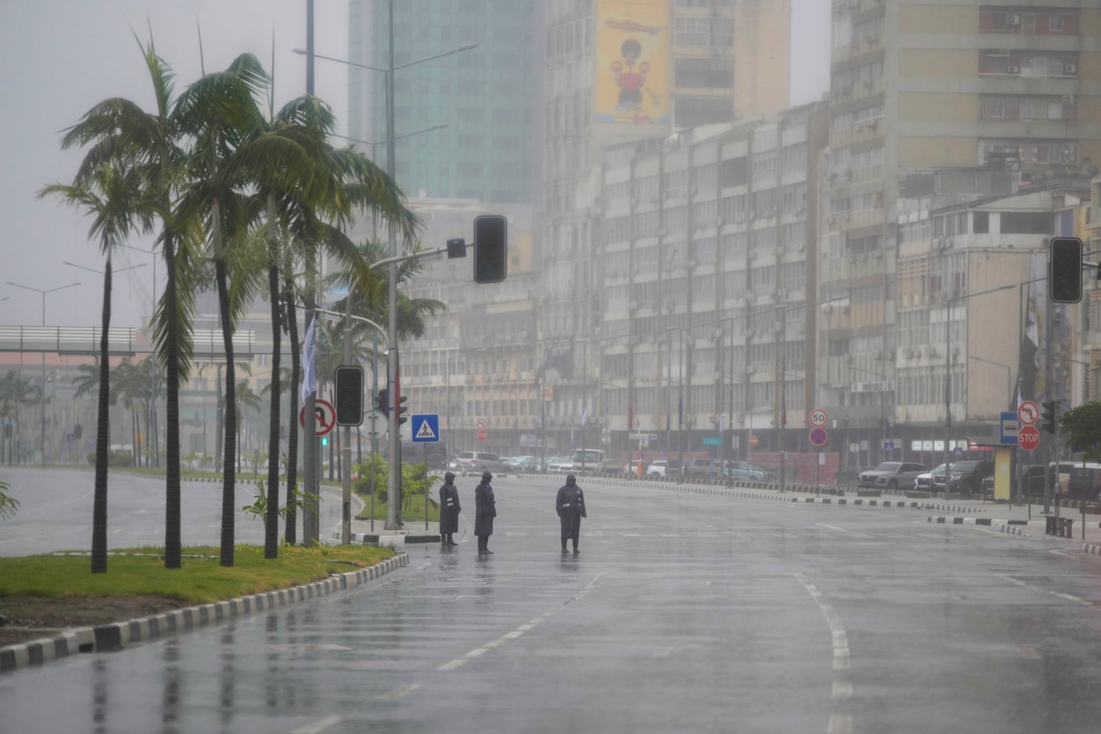 Seen through a vehicle window, Angolan soldiers stand on the route of President Joe Biden's motorcade in the rain in the capital Luanda, Angola on Tuesday, Dec. 3, 2024. (AP Photo/Ben Curtis)