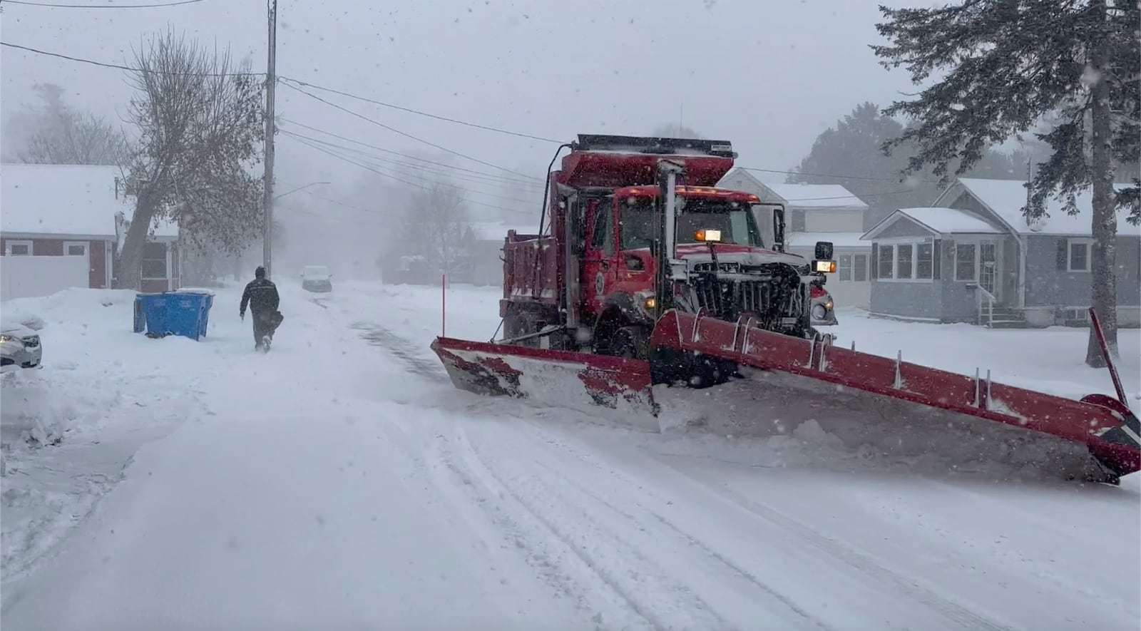 Snow is cleared from a snowy street in Lowville, N.Y. on Thursday, Dec. 12, 2024. (AP Photo/Cara Anna)