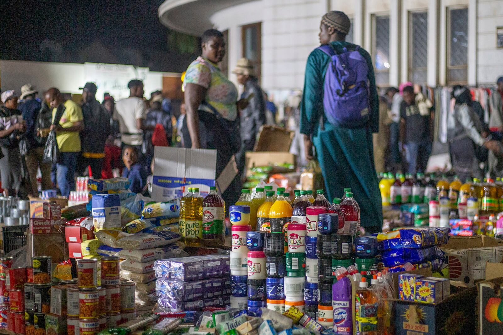 People shop at informal and illegal markets that pop up at night to avoid police raids in central Harare, Zimbabwe, Friday, Nov. 11, 2024. (AP Photo/Aaron Ufumeli)