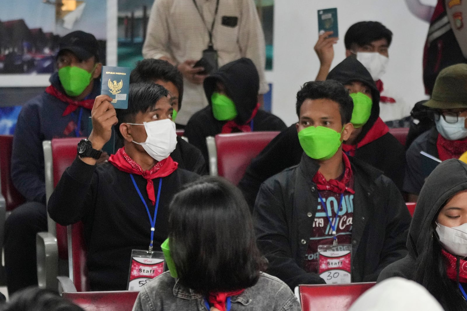 FILE- Indonesians who were forced to work at scam centers in eastern Myanmar hold up their while arriving at Soekarno-Hatta International Airport in Tangerang, Indonesia, Friday, Feb. 28, 2025.(AP Photo/Tatan Syuflana, File)