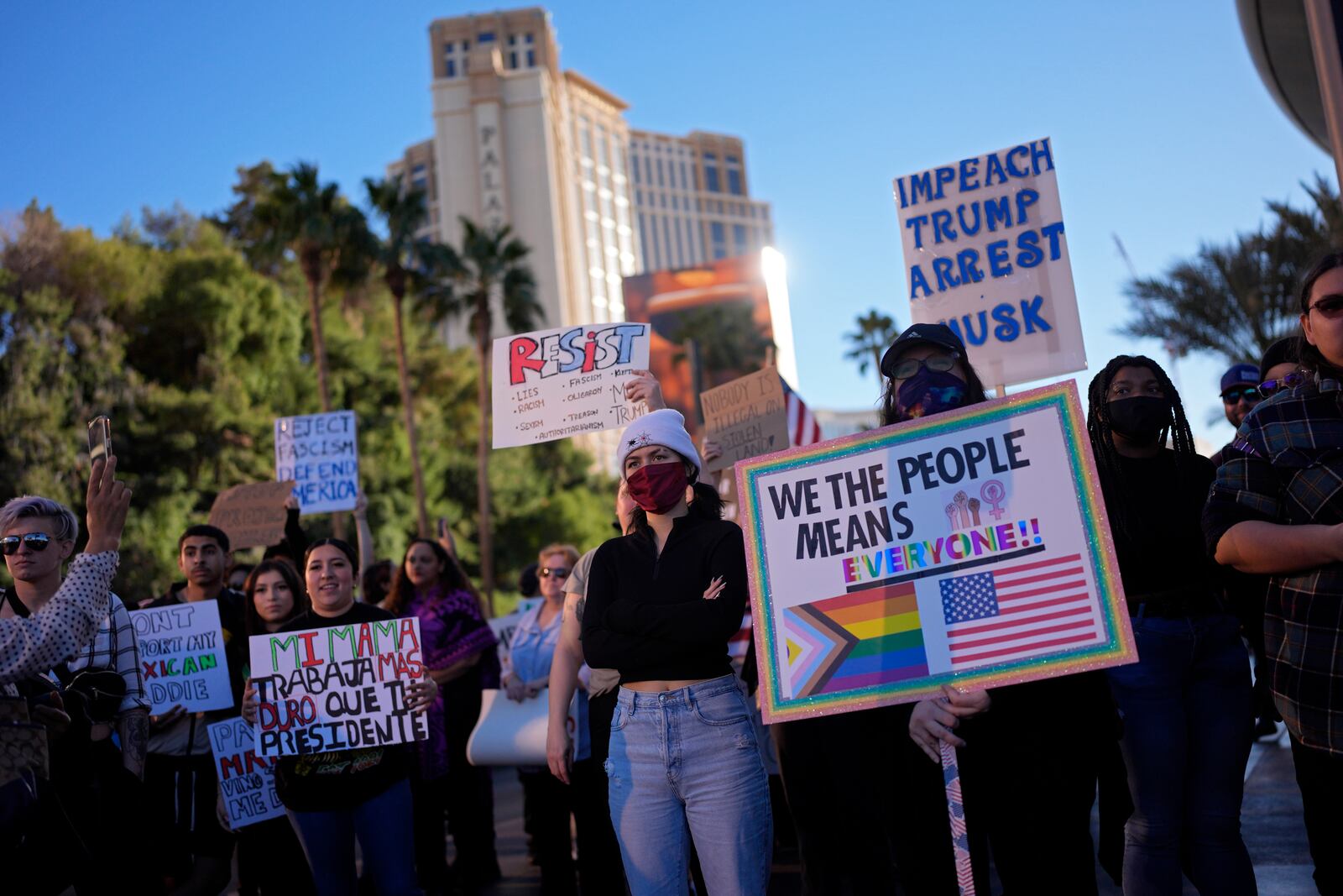 Demonstrators hold signs to protest against the Trump administration near the Trump International Hotel along the Las Vegas Strip, Wednesday, Feb. 5, 2025, in Las Vegas. (AP Photo/John Locher)