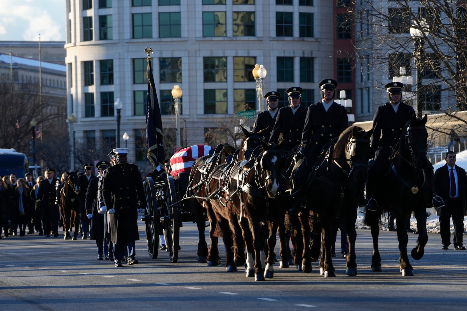 The casket containing the remains of former President Jimmy Carter moves on Constitution Avenue toward the U.S. Capitol on a horse-drawn caisson in Washington, Tuesday, Jan. 7, 2025. Carter died Dec. 29, 2024, at the age of 100. (AP Photo/Susan Walsh, Pool)