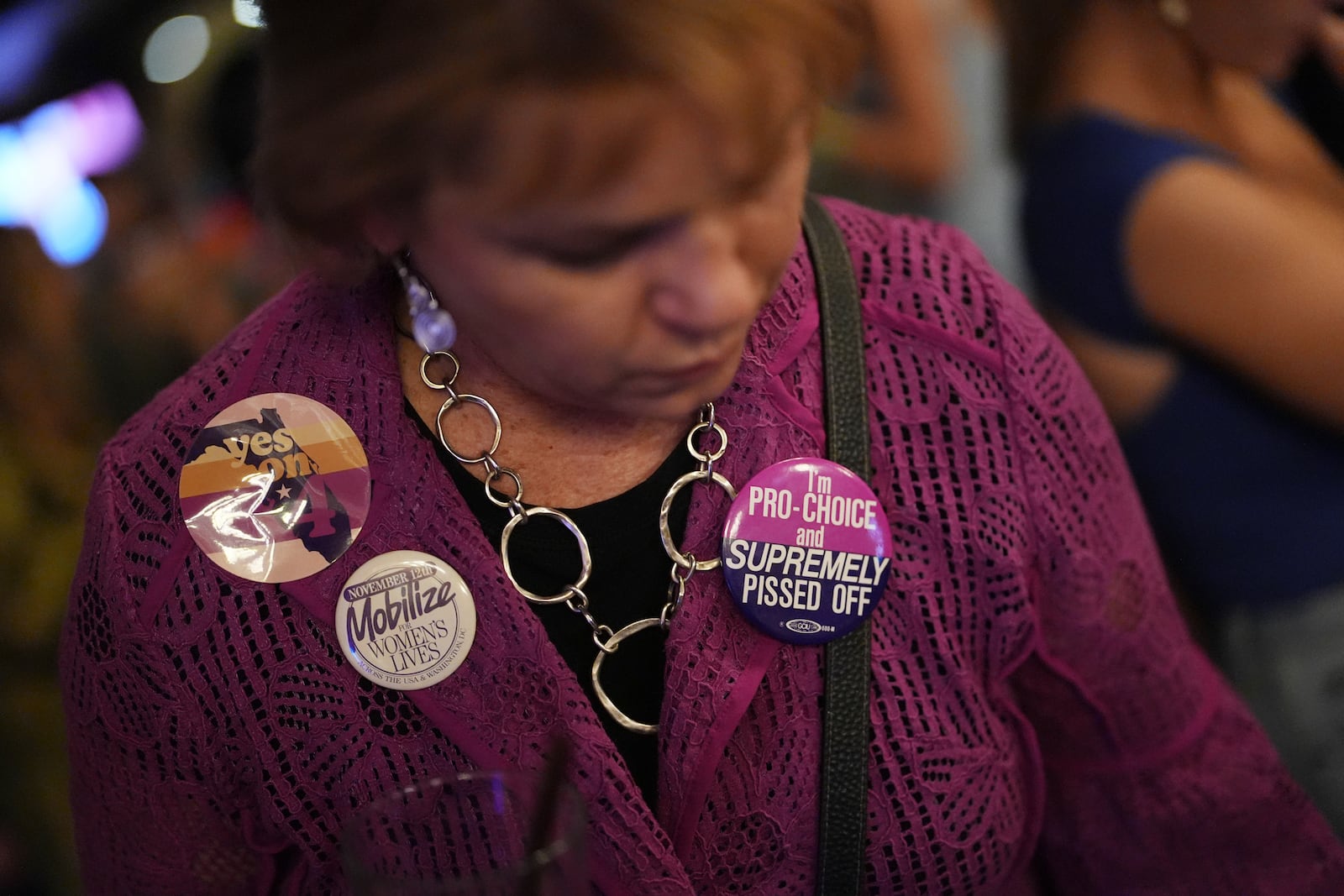 Denise Yettow wears a pair of buttons she saved from the 1989 Mobilize for Women's Lives Rally, as she gathers with supporters of Florida's Amendment 4, which would enshrine abortion rights in the state, for a watch party for the Yes On 4 campaign, on Election Day, Tuesday, Nov. 5, 2024, in St. Petersburg, Fla. (AP Photo/Rebecca Blackwell)