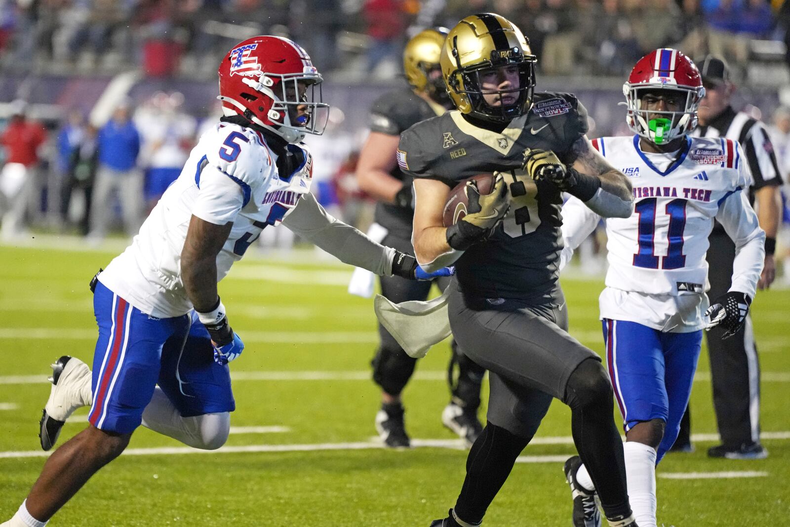 Army running back Hayden Reed (8) runs past Louisiana Tech defensive back Michael Richard (5) on his way to a 12-yard touchdown run during the first half of the Independence Bowl NCAA college football game, Saturday, Dec. 28, 2024, in Shreveport, La. (AP Photo/Rogelio V. Solis)