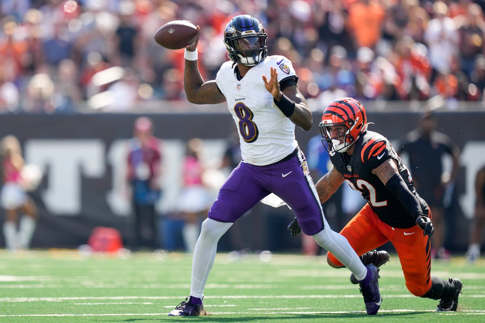 Baltimore Ravens quarterback Lamar Jackson, left, attempts a pass as Cincinnati Bengals safety Geno Stone (22) applies pressure during the first half of an NFL football game, Sunday, Oct. 6, 2024, in Cincinnati. (AP Photo/Carolyn Kaster)