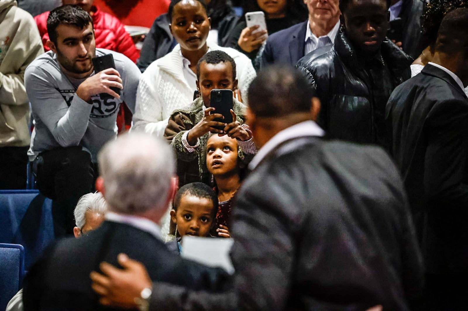 Claude Nkurunzizh, right, is photographed by his family with naturalization judge Guy Humphrey after the ceremony at Springboro High School. Jim Noelker/Staff