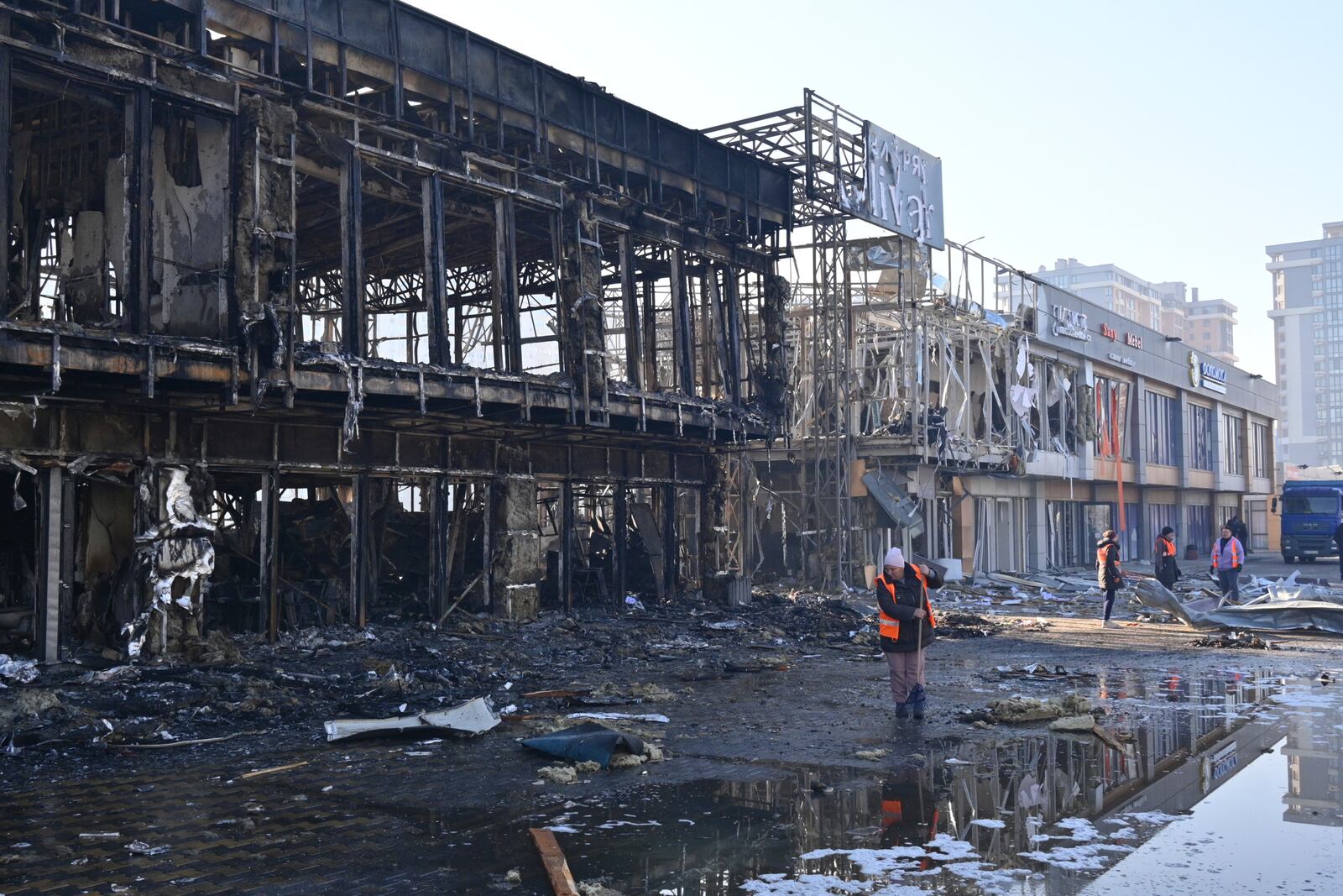 Municipal workers clean up after Russian drones hit shops during the night attack in Odesa, Ukraine, Friday, March 21, 2025. (AP Photo/Michael Shtekel)