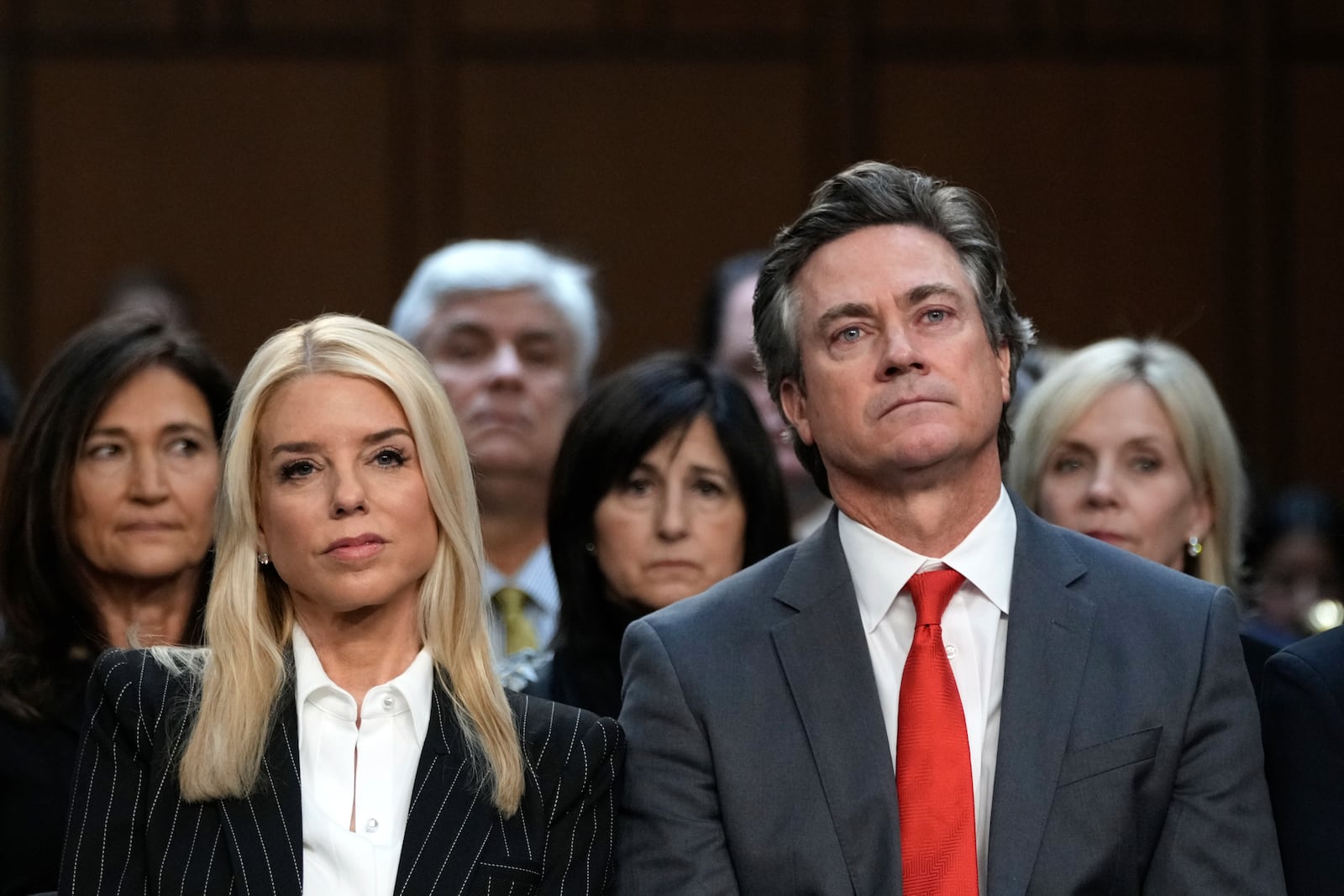 Pam Bondi, President-elect Donald Trump's choice to lead the Justice Department as attorney general, and her partner John Wakefield listen during the Senate Judiciary Committee for her confirmation hearing, at the Capitol in Washington, Wednesday, Jan. 15, 2025. (AP Photo/Ben Curtis)