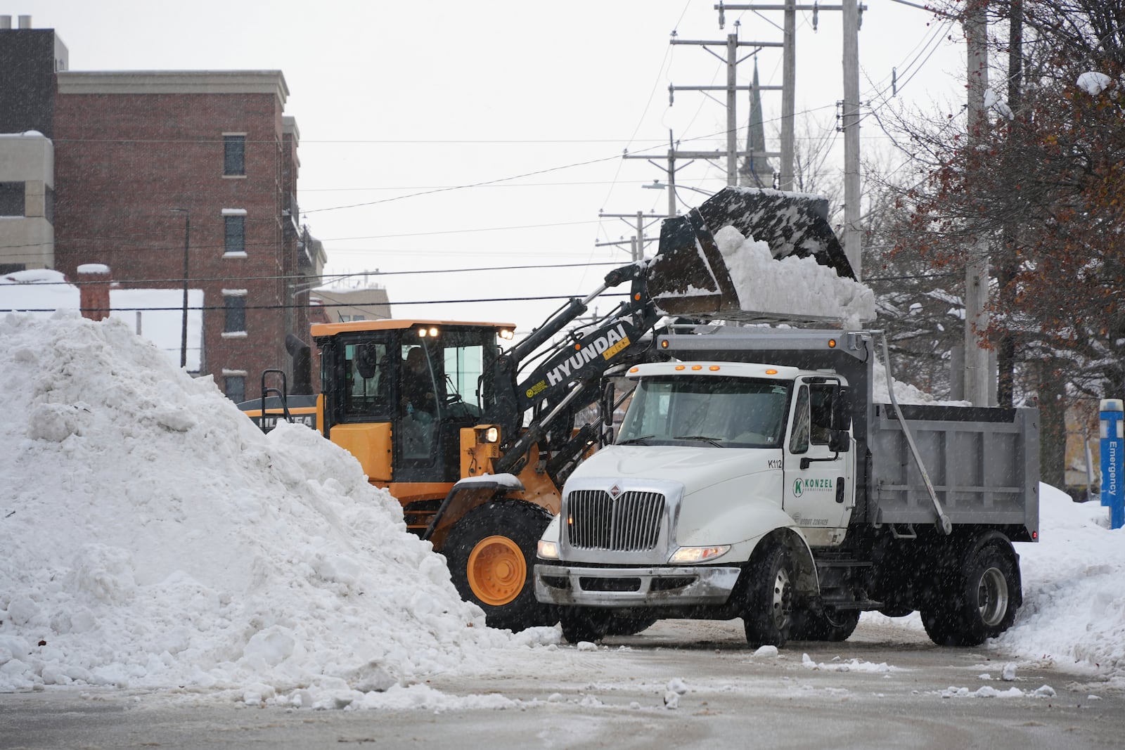 Workers clear snow on side streets Monday, Dec 2, 2024, In Erie, Pa. (AP Photo/Gene J. Puskar)