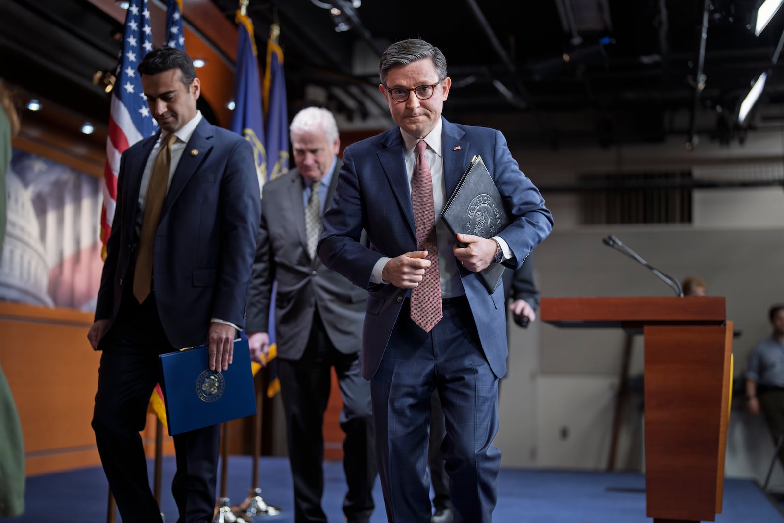 Speaker of the House Mike Johnson, R-La., center, departs a news conference joined from left by Rep. Abraham Hamadeh, R-Ariz., and House Majority Whip Tom Emmer, R-Minn., after discussing work on a spending bill, at the Capitol in Washington, Tuesday, Feb. 11, 2025. (AP Photo/J. Scott Applewhite)