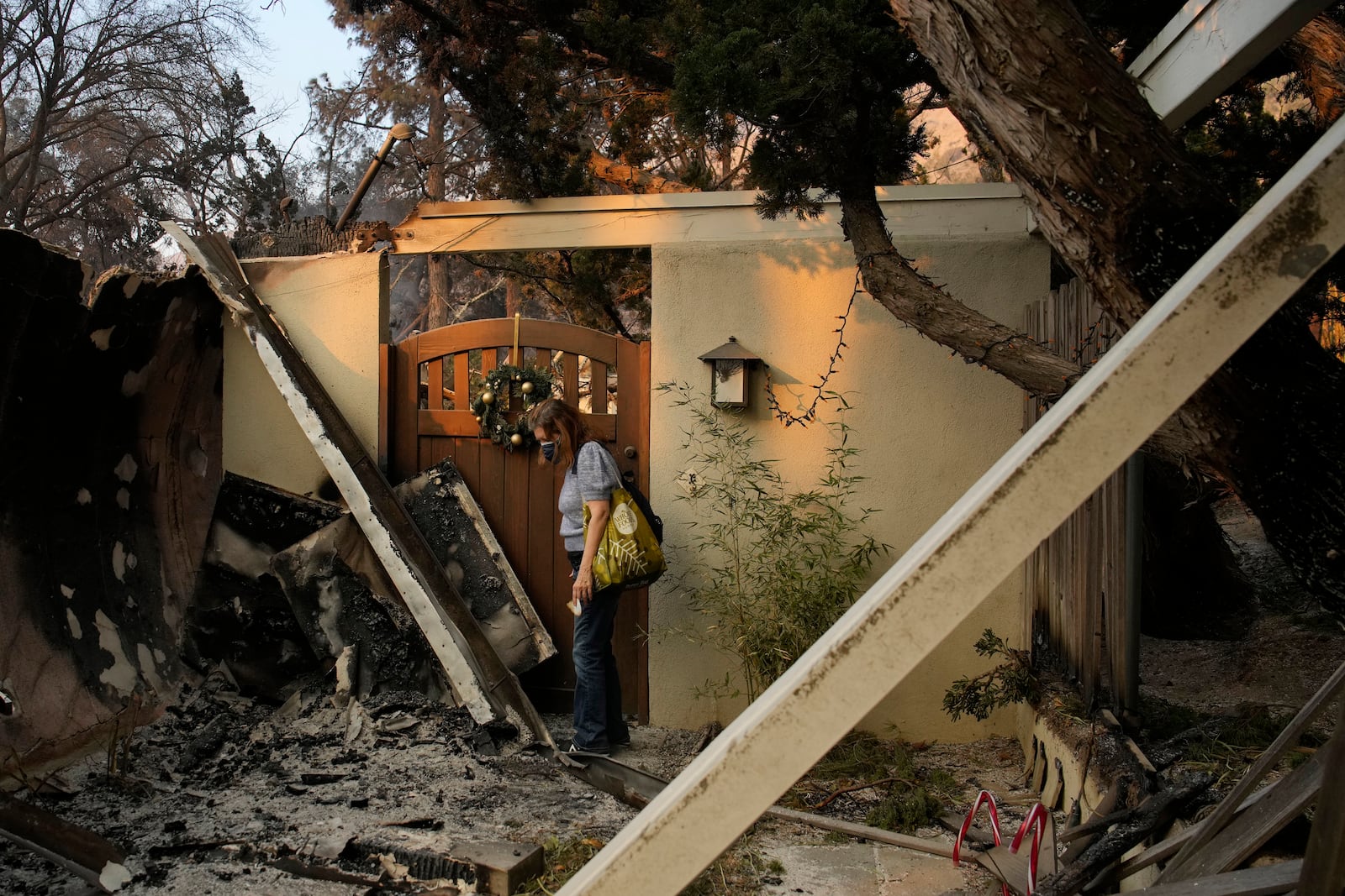 Glenda, who declined to give her last name, stands near the entrance of her home destroyed by the Eaton fire Thursday, Jan. 9, 2025, in Altadena, Calif. (AP Photo/John Locher)