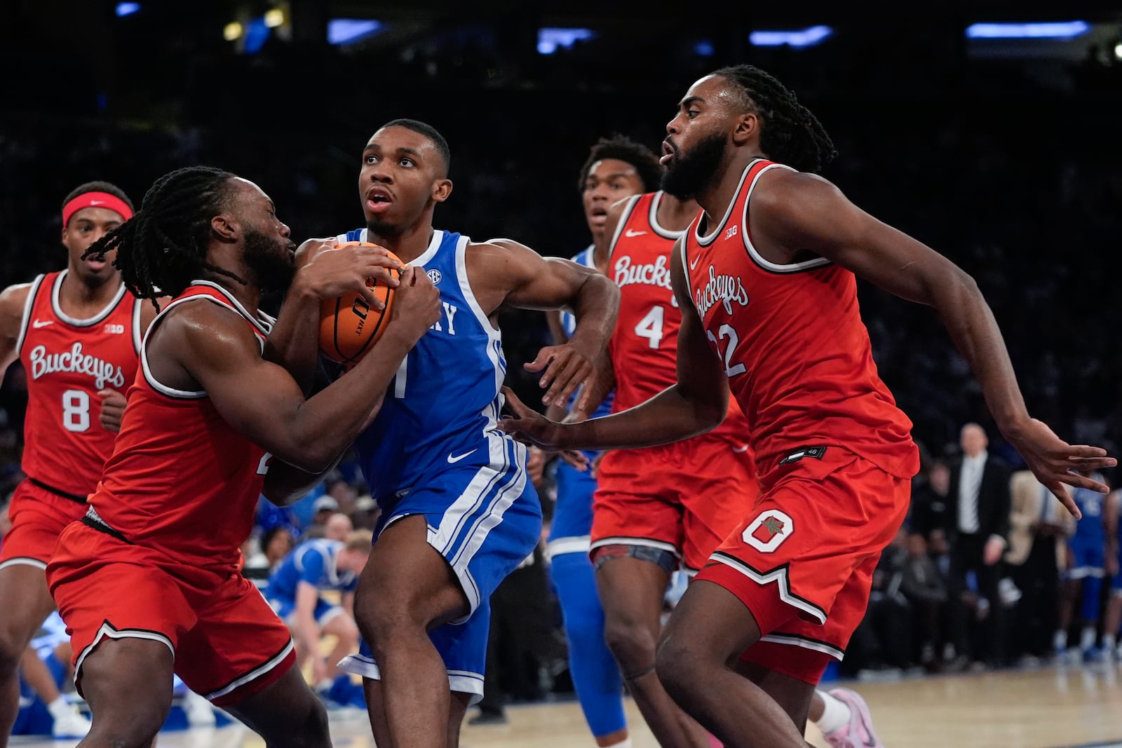 Ohio State's Bruce Thornton, left, fights for control of the ball with Kentucky's Lamont Butler as Evan Mahaffey, right, watches during the first half of an NCAA college basketball game in the CBS Sports Classic, Saturday, Dec. 21, 2024, in New York. (AP Photo/Frank Franklin II)