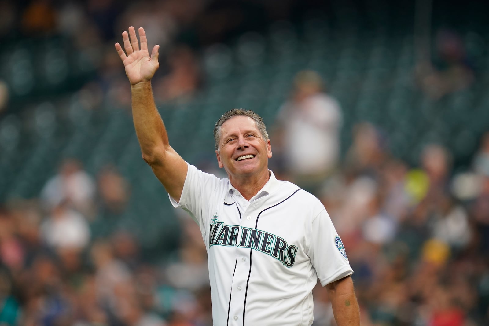 FILE - Former Seattle Seahawks wide receiver Steve Largent waves to fans before throwing out the ceremonial first pitch before a baseball game between the Seattle Mariners and the Toronto Blue Jays, Aug. 13, 2021, in Seattle. (AP Photo/Elaine Thompson, File)