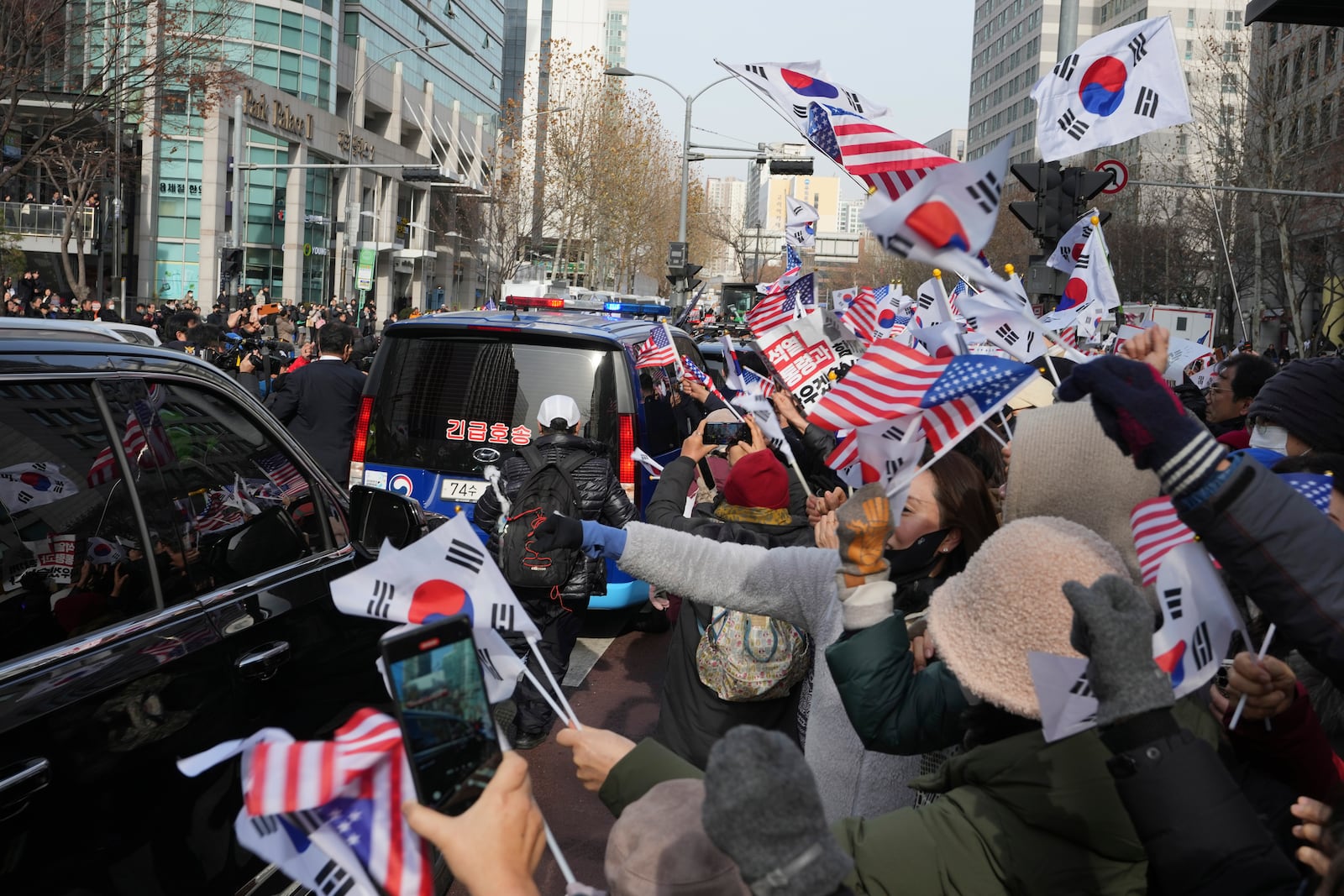 Supporters for impeached South Korean President Yoon Suk Yeol greet as his motorcade passes by near the Seoul Western District Court in Seoul, South Korea, Saturday, Jan. 18, 2025. (AP Photo/Lee Jin-man)