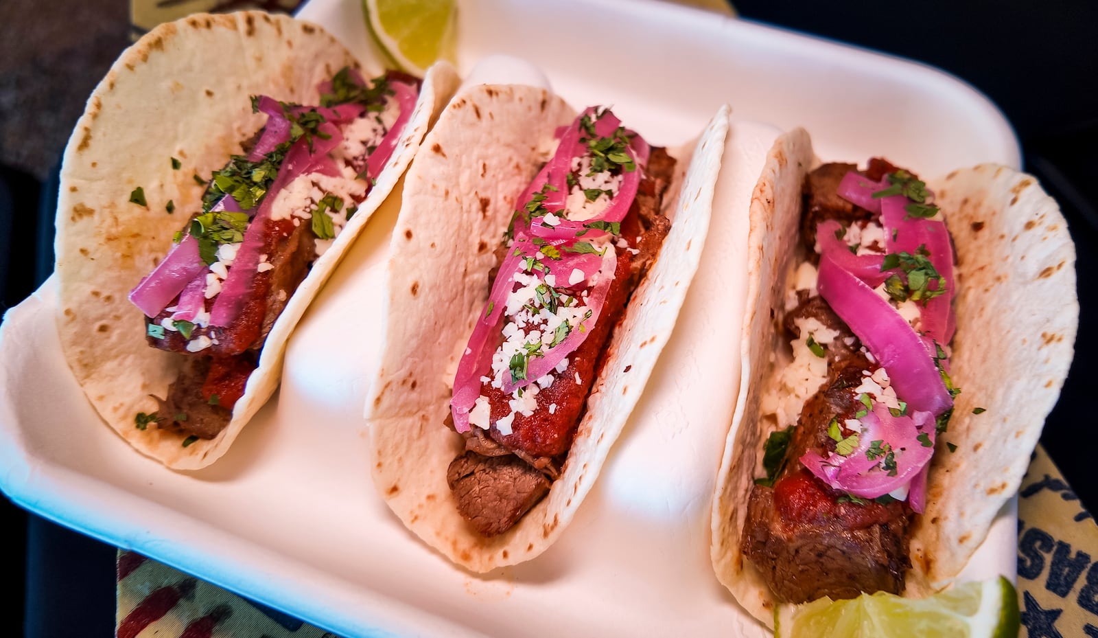 The Cincinnati Reds announced new menu items ahead of opening day on Friday, March 21, 2025 in The Handlebar at the Riverfront Club inside Great American Ball Park in Cincinnati. Executive Chef Gary Davis created a variety of new dishes for the upcoming season. This is the Carne Asada Street Tacos with three flour tortillas topped with steak, salsa roja, pickled red onions, cotija cheese and cilantro. NICK GRAHAM/STAFF