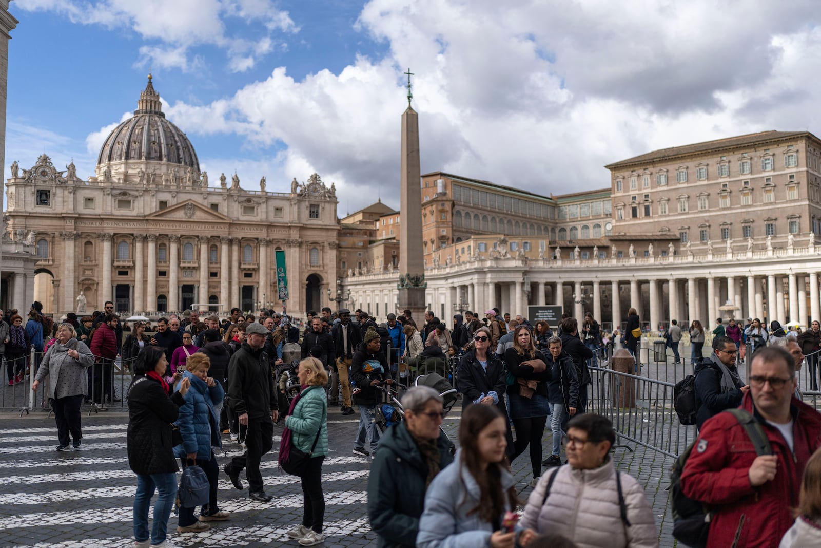 People walk in St. Peter's square at The Vatican, Friday, Feb. 28, 2025. (AP Photo/Mosa'ab Elshamy)