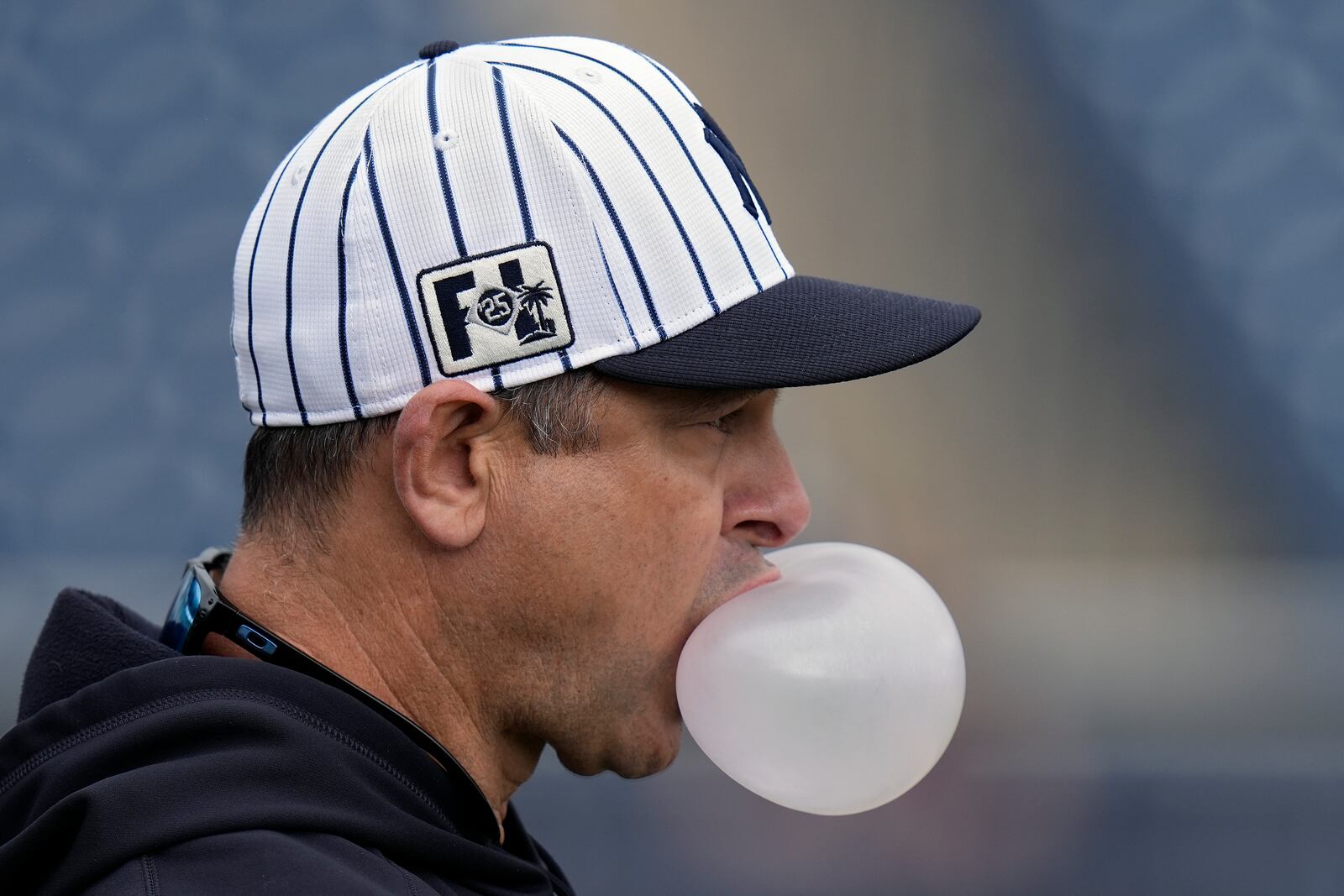 New York Yankees manager Aaron Boone blows a bubble as he watches drills during spring training baseball workouts, Thursday, Feb. 20, 2025, in Tampa, Fla. (AP Photo/Chris O'Meara)