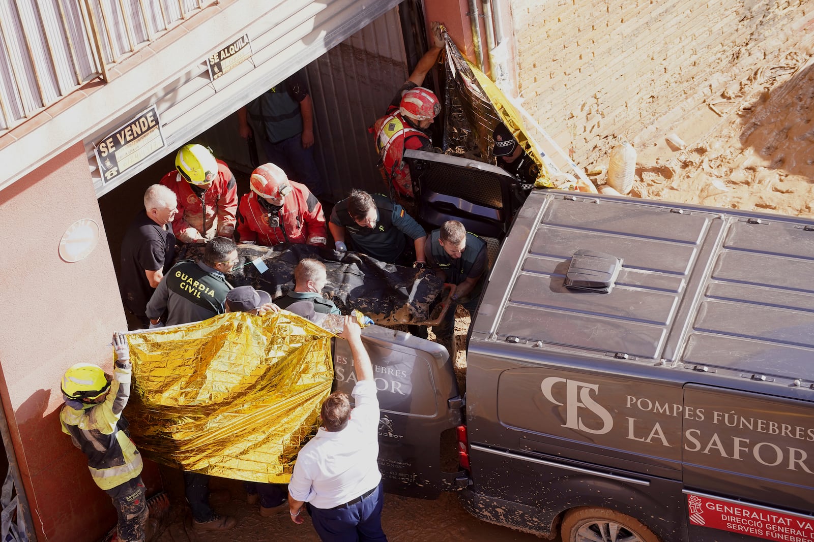 Members of the Spanish Guardia Civil carry the body of a person who died during floods in Valencia, Spain, Thursday, Oct. 31, 2024. (AP Photo/Alberto Saiz)