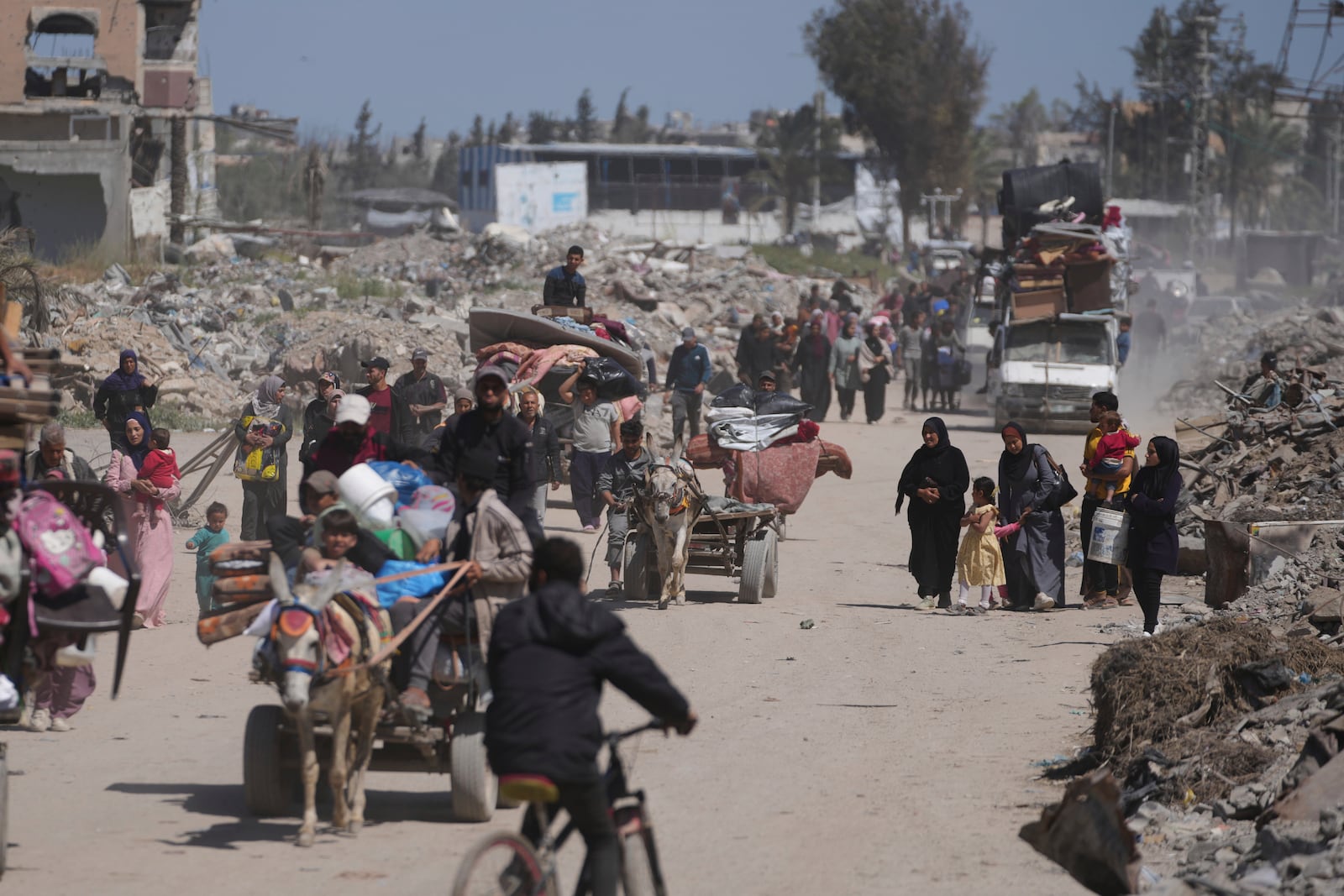 Displaced Palestinians, carrying their belongings traveling from Beit Hanoun to Jabaliya, a day after Israel's renewed offensive in the Gaza Strip, Wednesday, March 19, 2025. (AP Photo/Jehad Alshrafi)