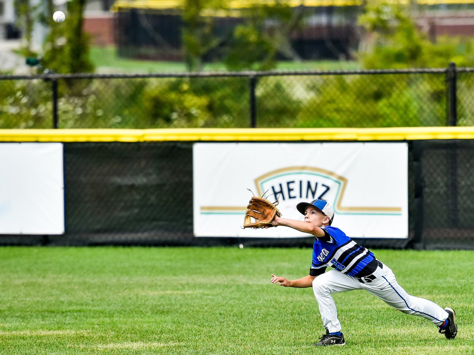 Hamilton West Side’s Clint Moak makes a diving catch Monday during their 10-2 win over Grosse Pointe Woods-Shores (Mich.) in the Little League Great Lakes Regional at Grand Park Sports Campus in Westfield, Ind. NICK GRAHAM/STAFF